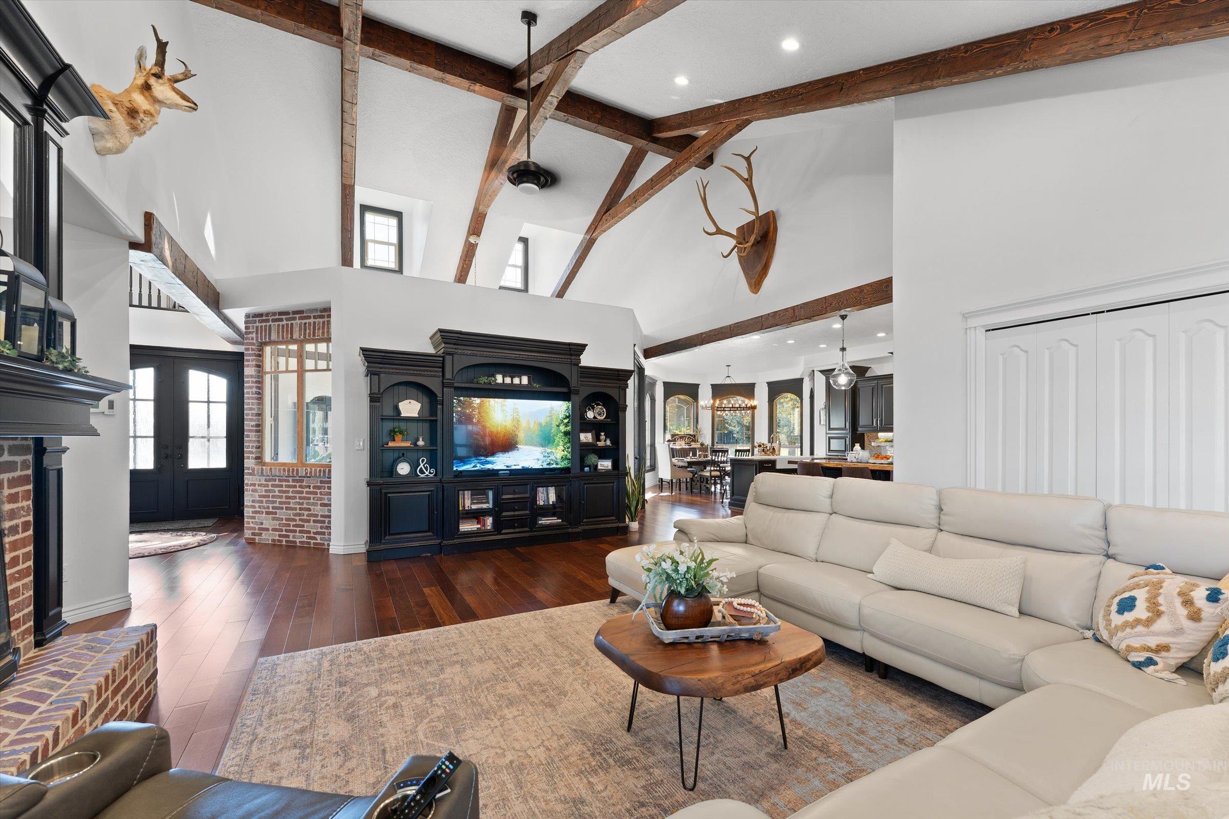 Living area featuring high vaulted ceiling, hardwood / wood-style floors, beam ceiling, french doors, and recessed lighting