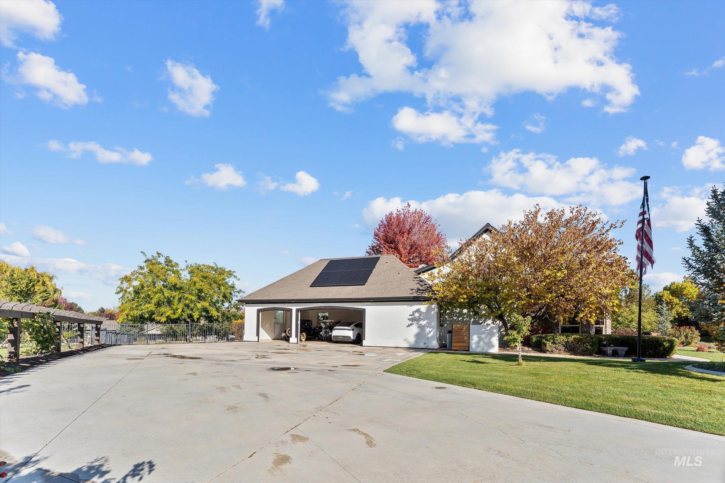 View of front of property with driveway and solar panels