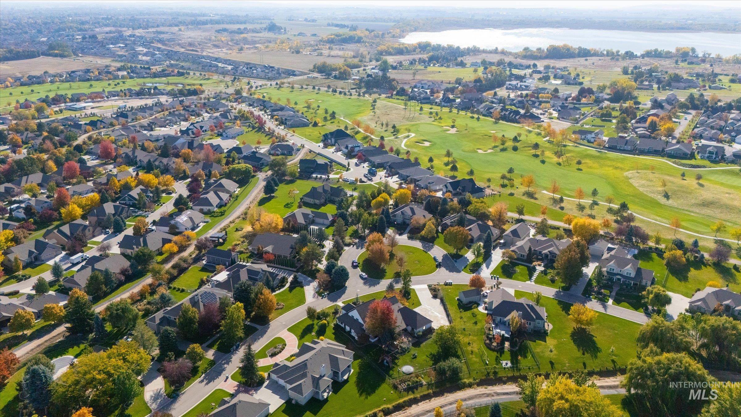 View of property location featuring nearby suburban area, a large body of water, and a golf club