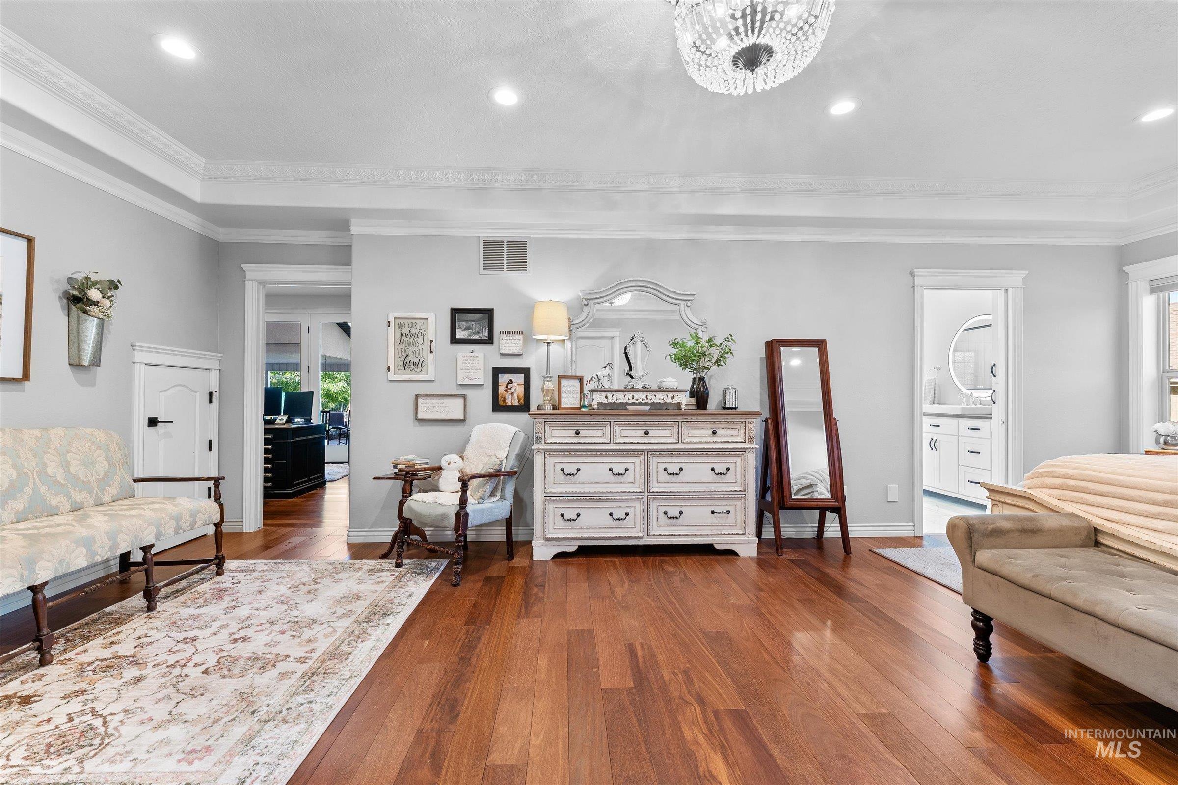 Bedroom area with dark wood-style flooring, recessed lighting, and ornamental molding