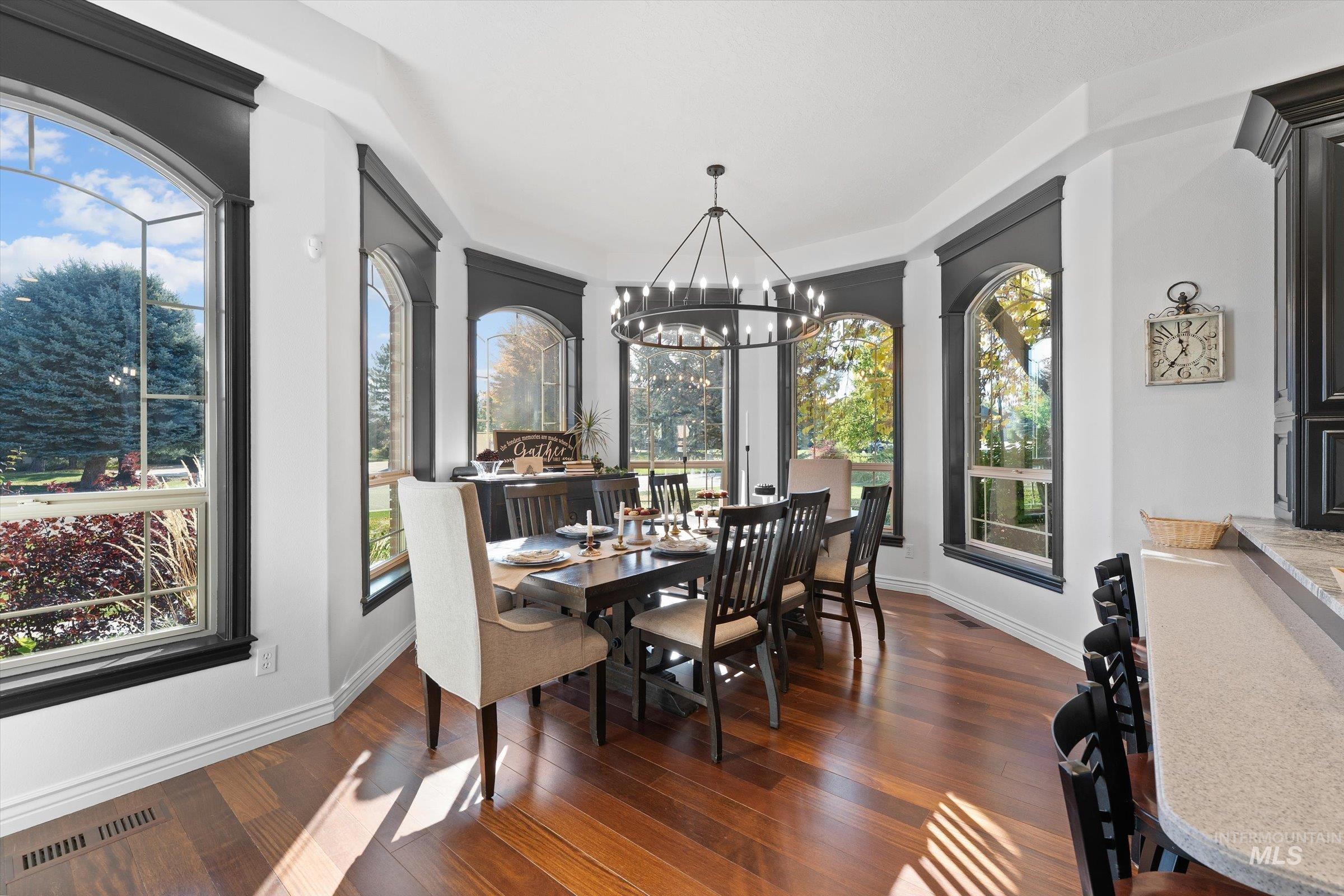 Dining room with dark wood-type flooring and a chandelier