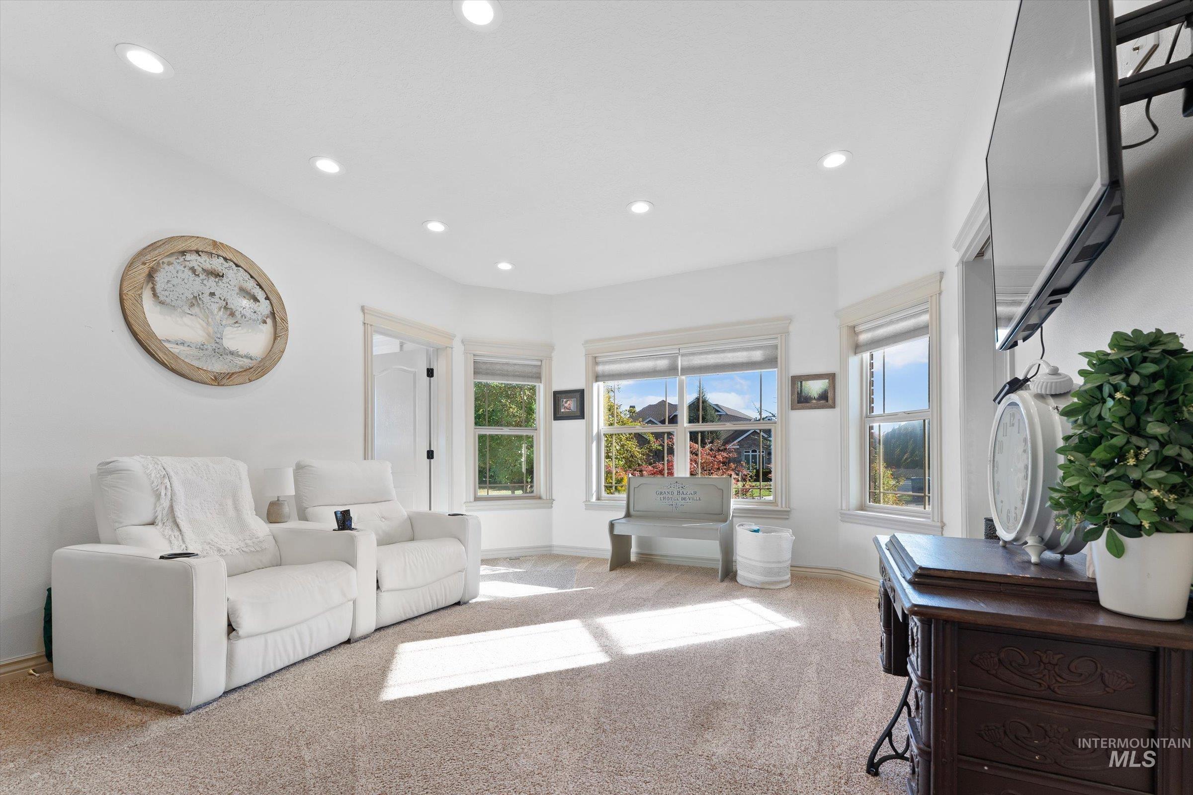 Living area featuring light colored carpet and recessed lighting