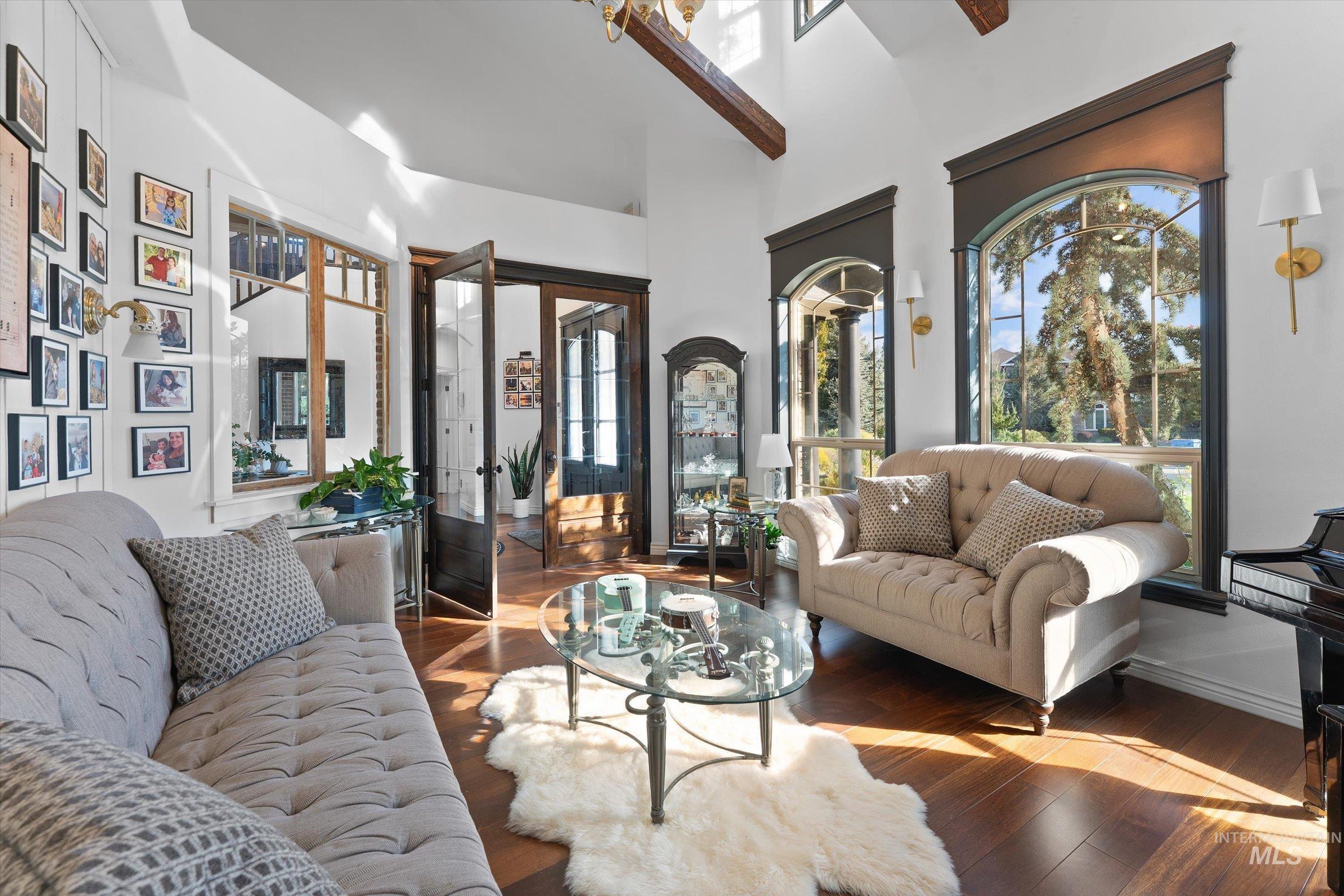 Living room with hardwood / wood-style floors, plenty of natural light, french doors, and a high ceiling