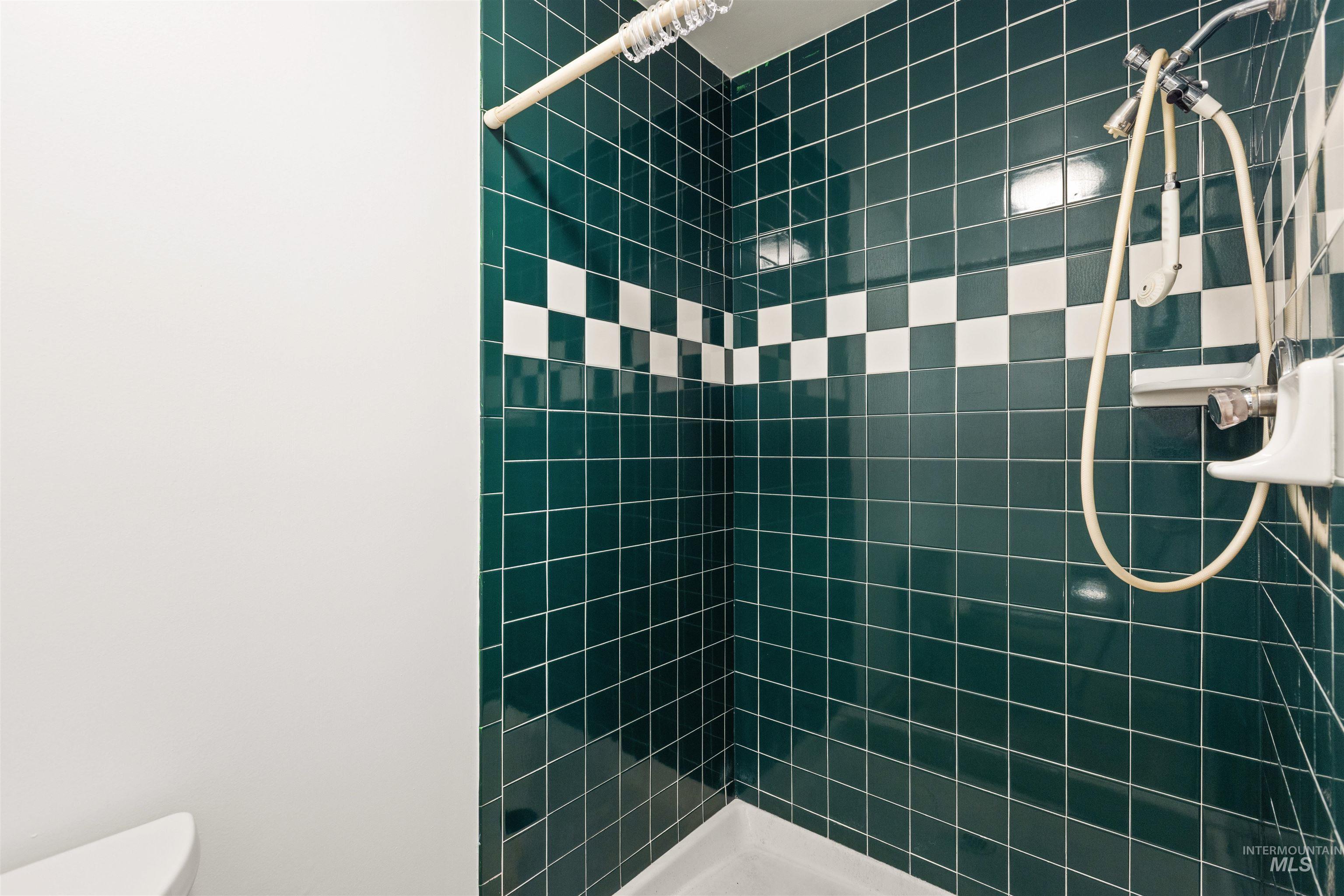 Full bathroom featuring tiled shower and toilet