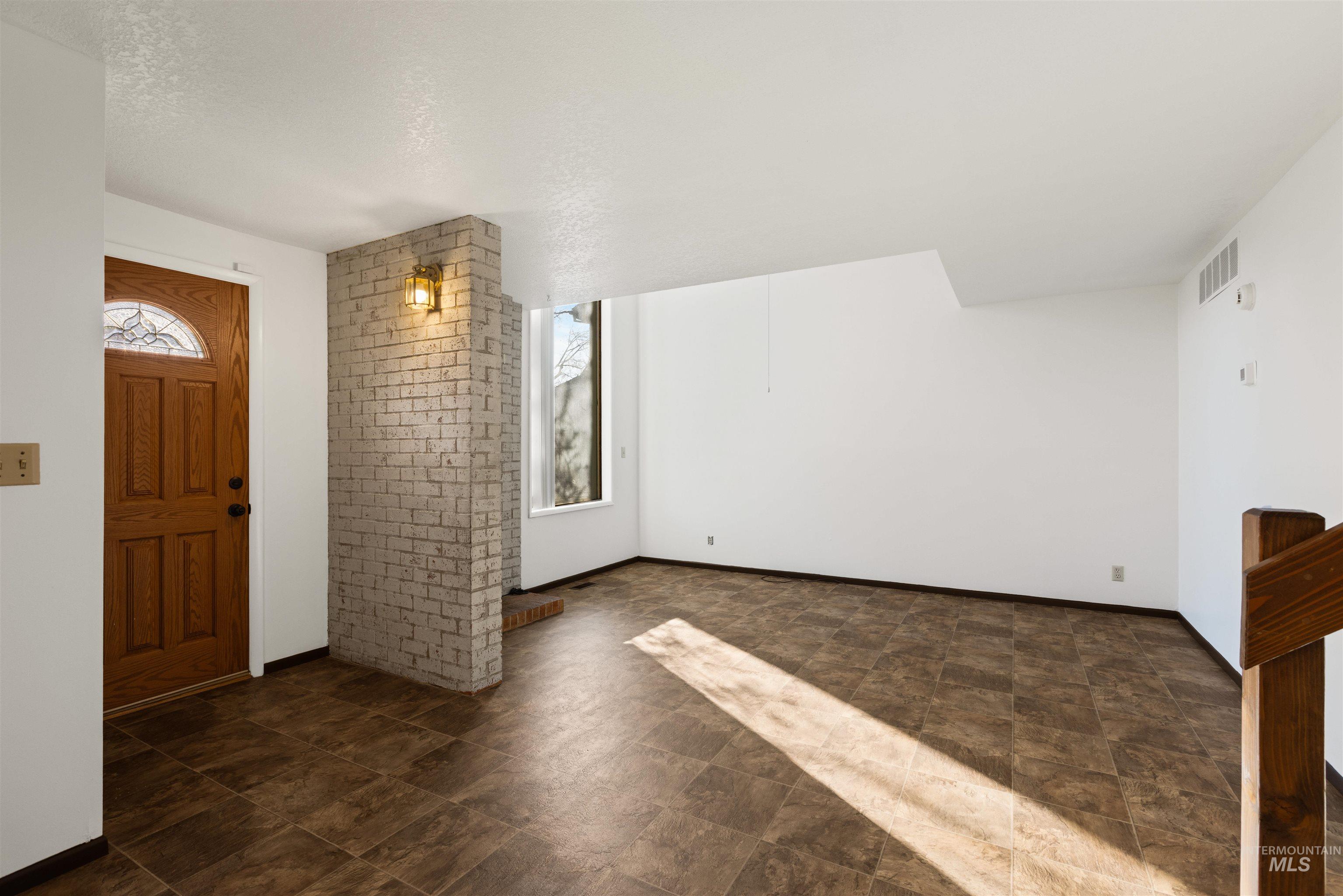 Entrance foyer with baseboards and stone finish floors