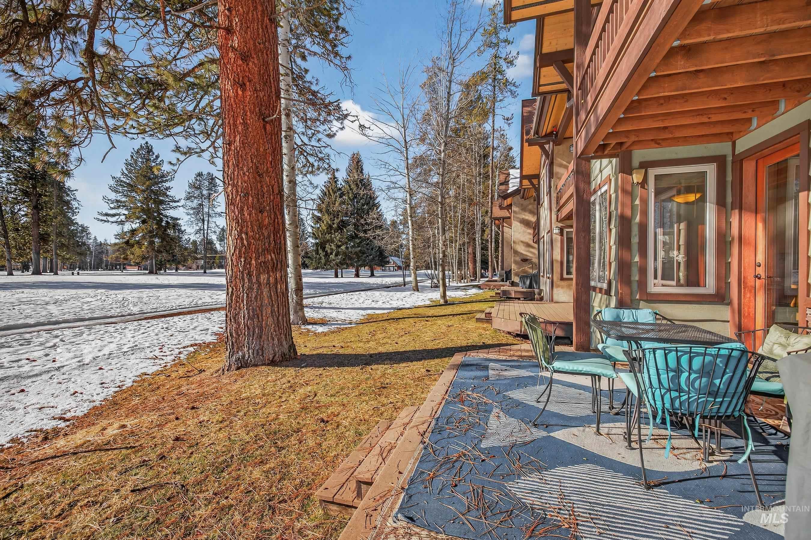 Yard layered in snow featuring a patio area and outdoor dining space