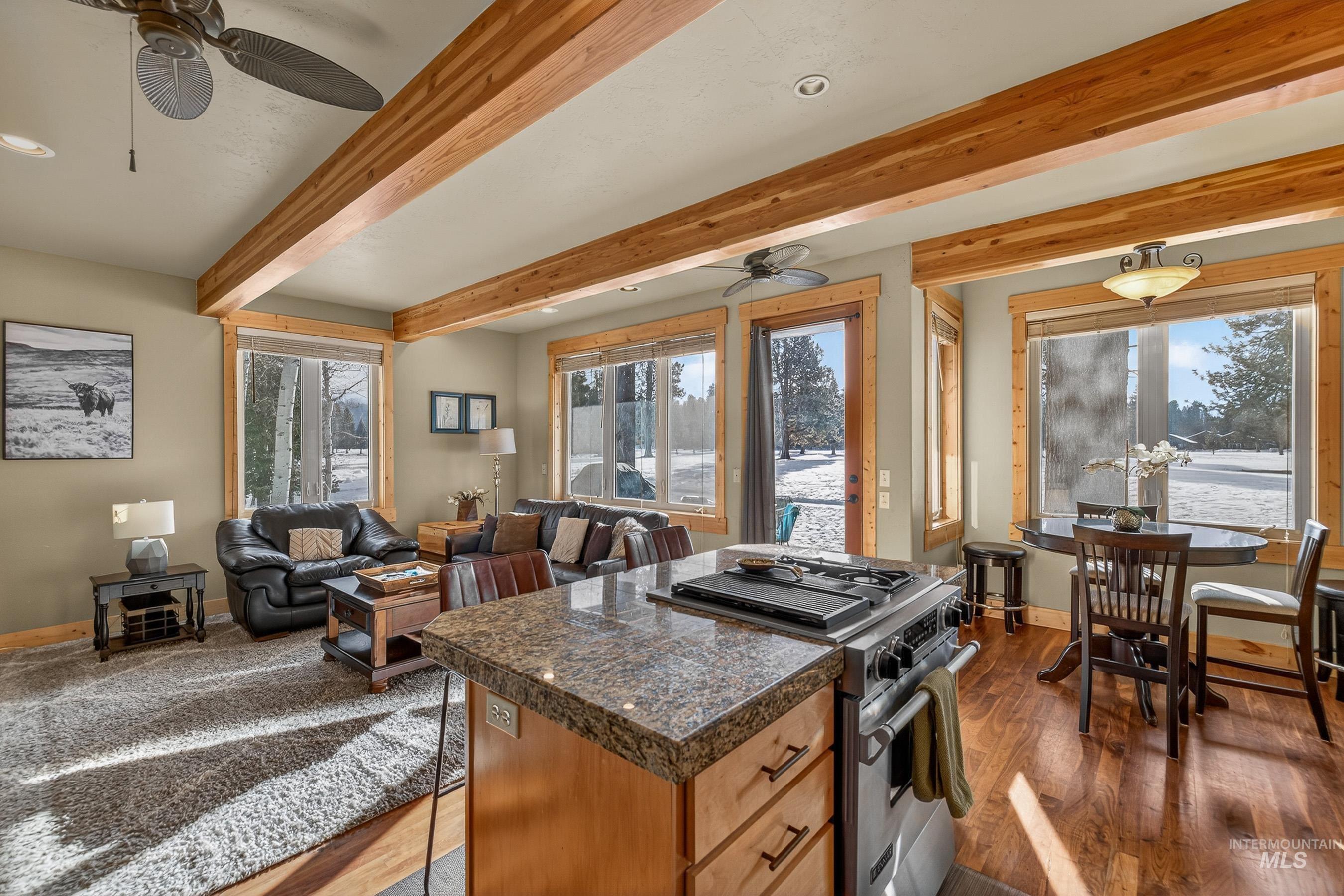 Kitchen with tile counters, stainless steel range, a ceiling fan, dark wood finished floors, and beam ceiling