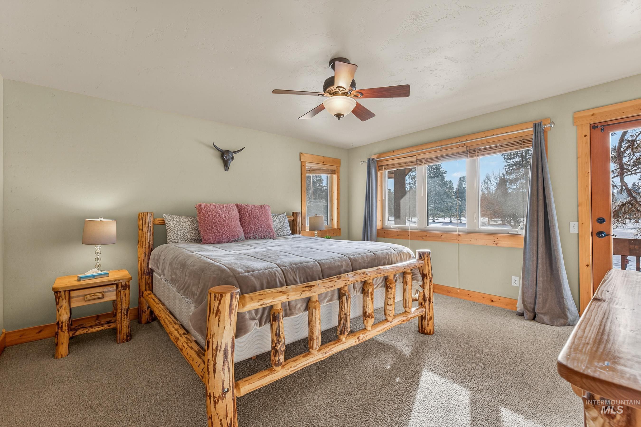 Bedroom with carpet flooring, a ceiling fan, and access to outside