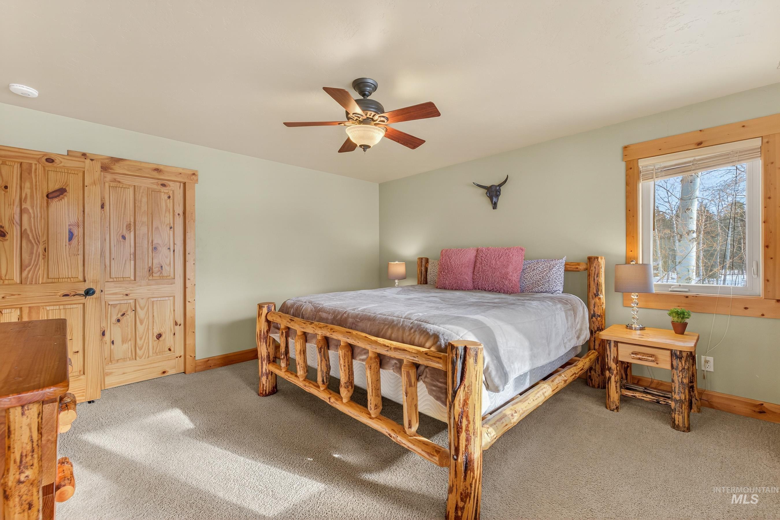 Bedroom with light carpet and a ceiling fan