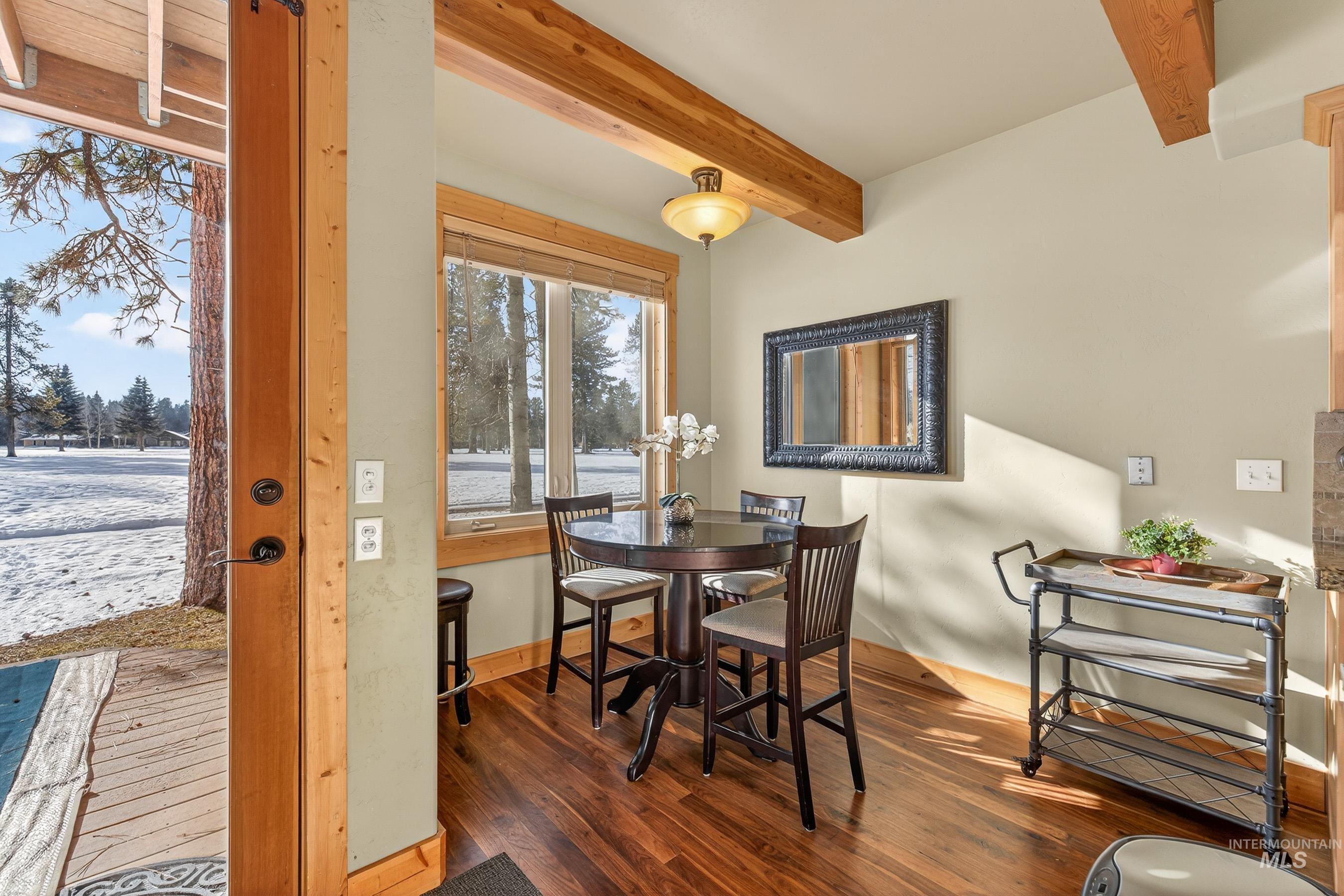 Dining room with hardwood / wood-style flooring and beam ceiling