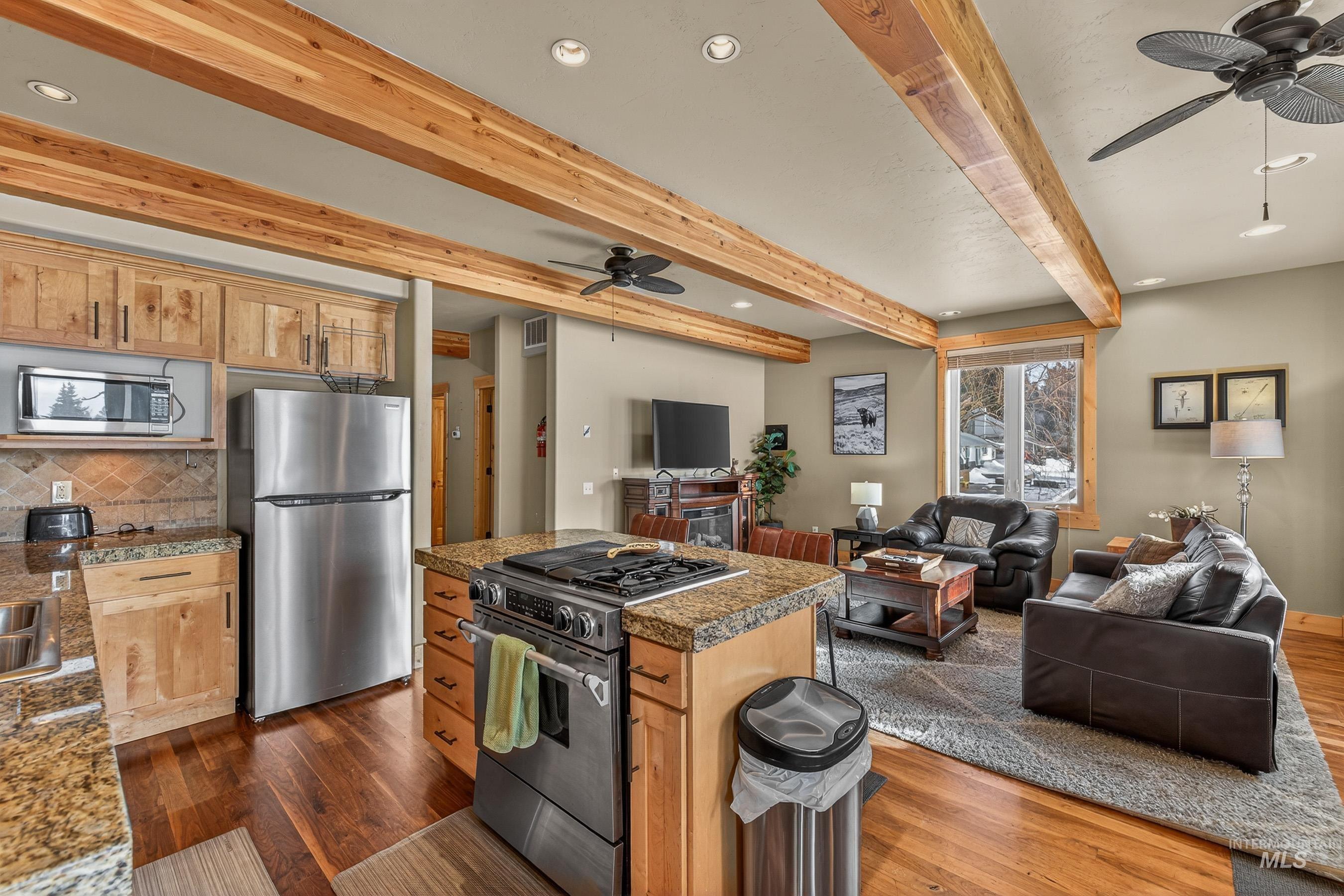 Kitchen featuring recessed lighting, a ceiling fan, open floor plan, appliances with stainless steel finishes, and beam ceiling