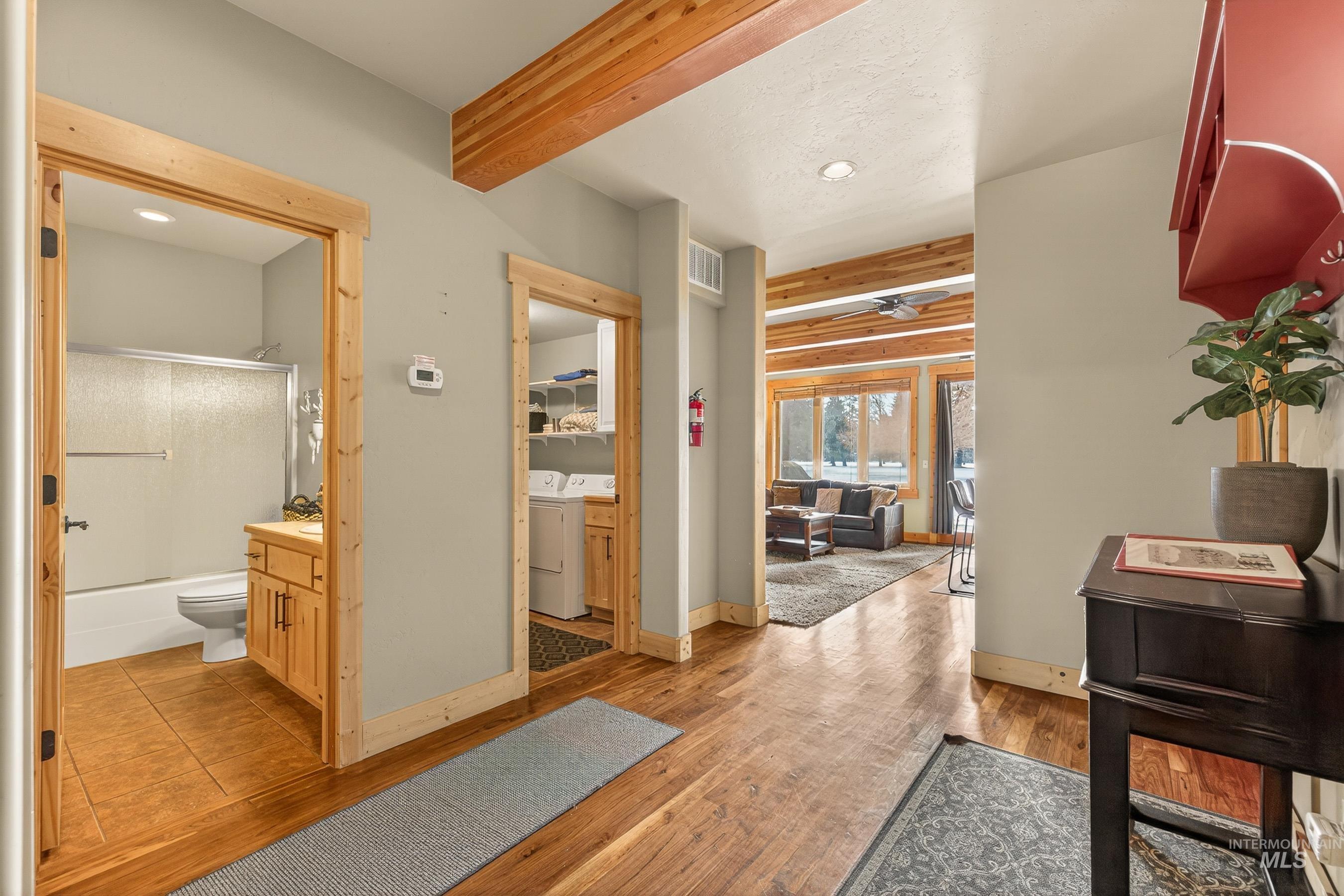 Corridor featuring beamed ceiling, light wood-type flooring, washer and clothes dryer, and recessed lighting