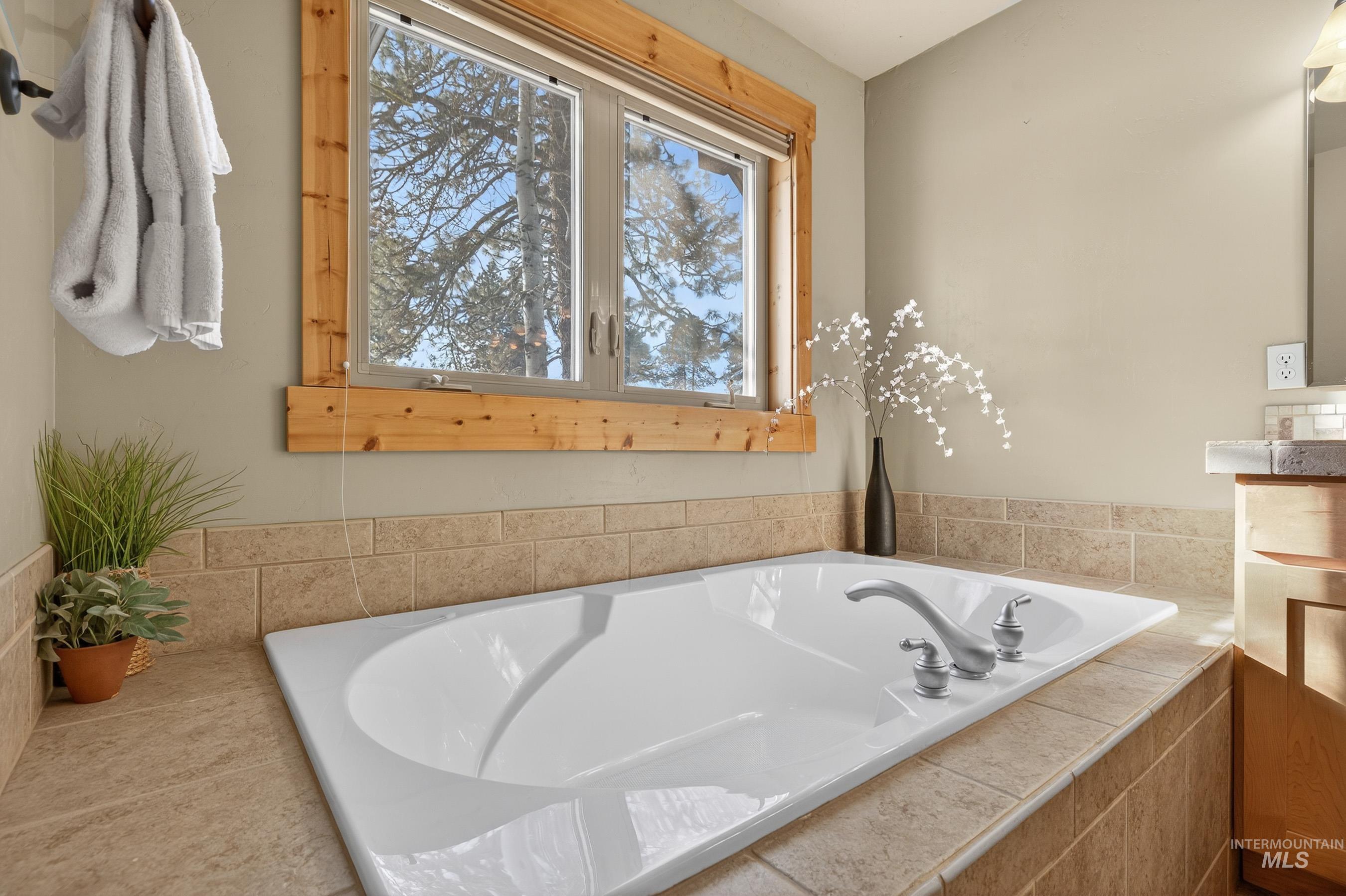 Full bathroom featuring a garden tub and vanity