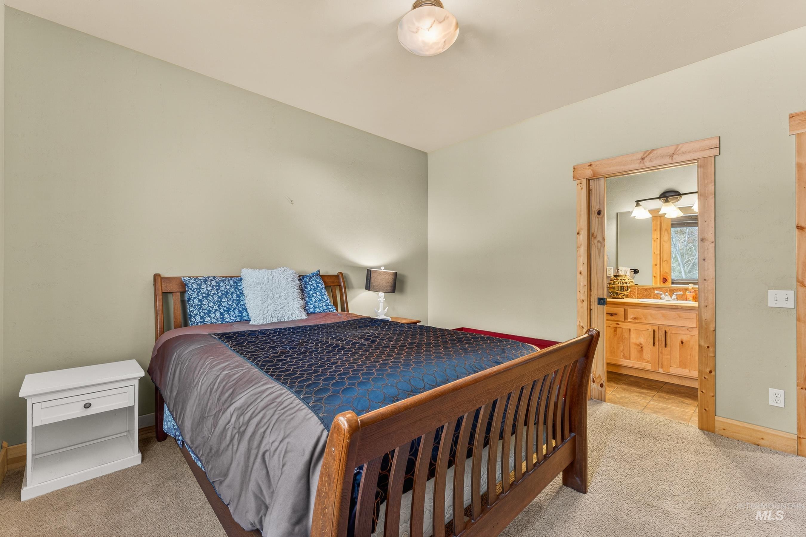 Bedroom with light carpet and ensuite bath