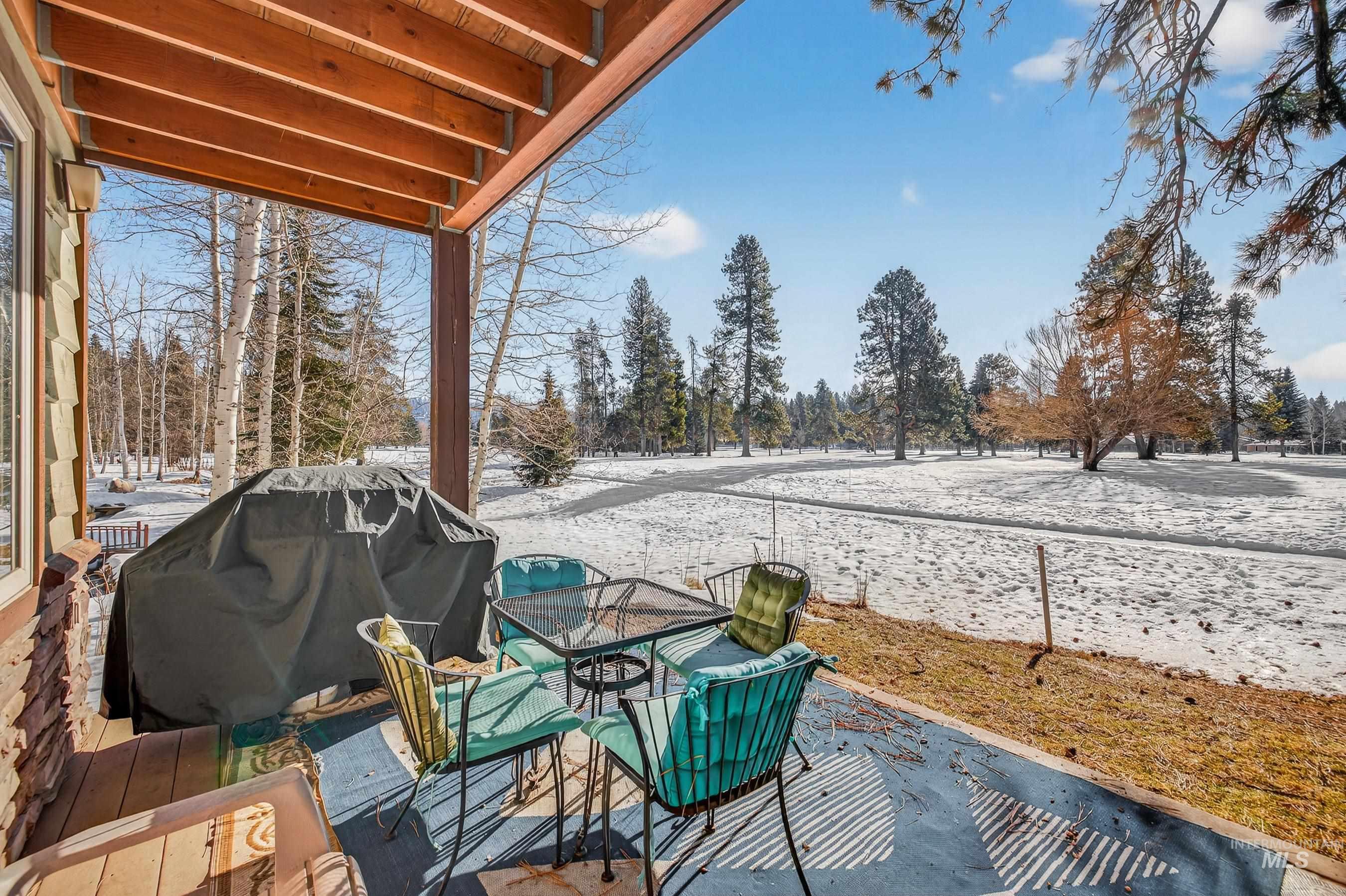 Snow covered deck featuring a grill and a patio area
