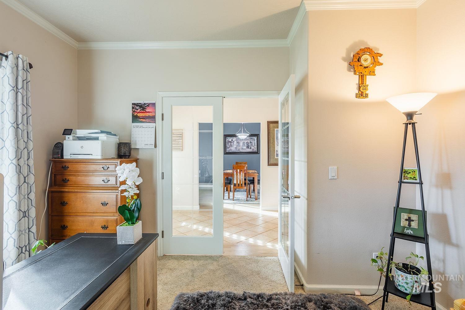 Office space featuring french doors, light carpet, and ornamental molding