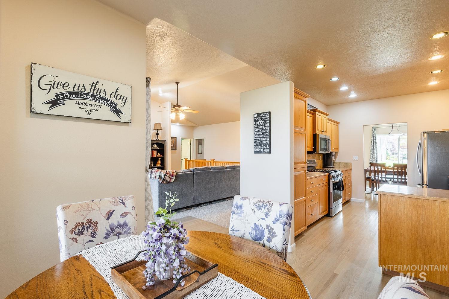 Dining room featuring light wood-style flooring, recessed lighting, a ceiling fan, and a textured ceiling