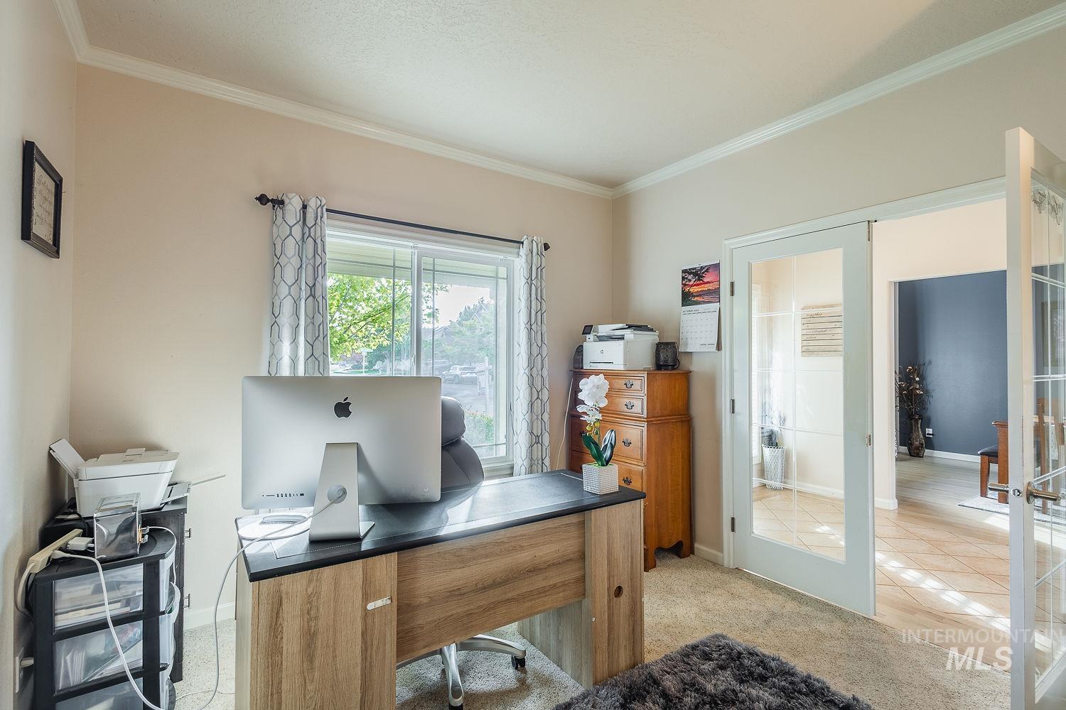 Office area with crown molding, french doors, and light carpet