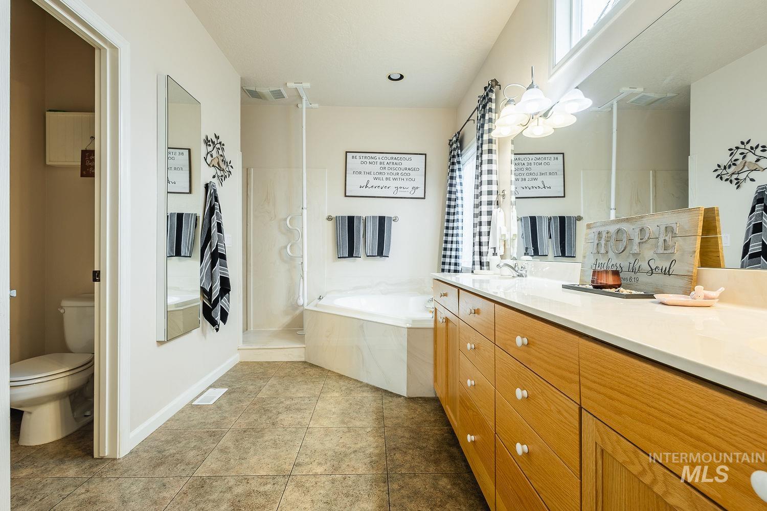 Full bath featuring a bath, a shower stall, light tile patterned flooring, and vanity