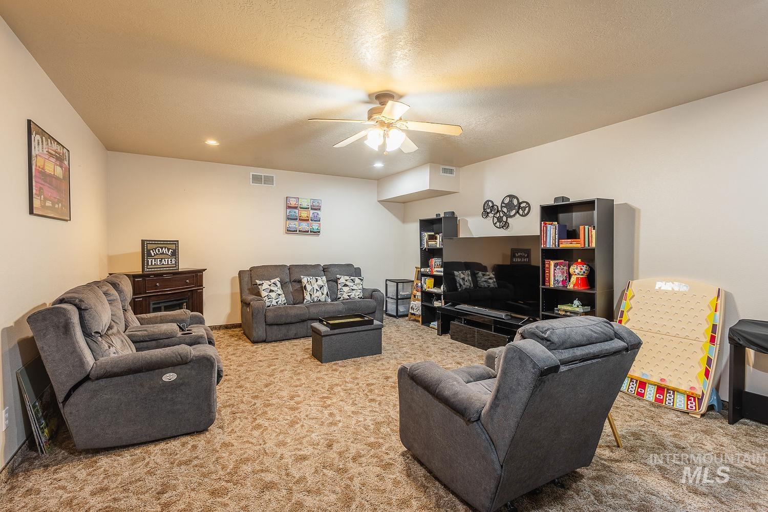 Living area featuring carpet floors, a ceiling fan, recessed lighting, and a textured ceiling