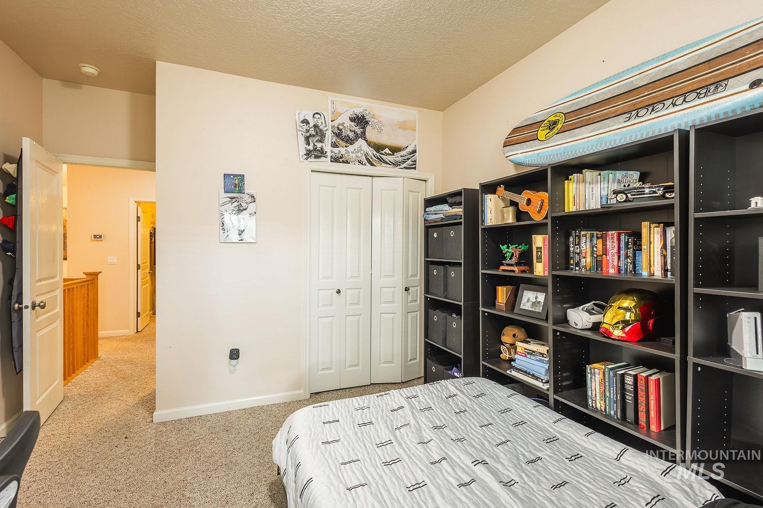 Bedroom featuring a textured ceiling, light carpet, and a closet