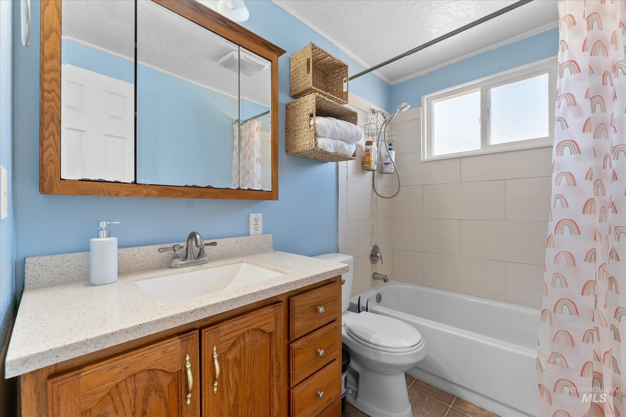 Full bathroom with shower / bath combo, vanity, and tile patterned floors