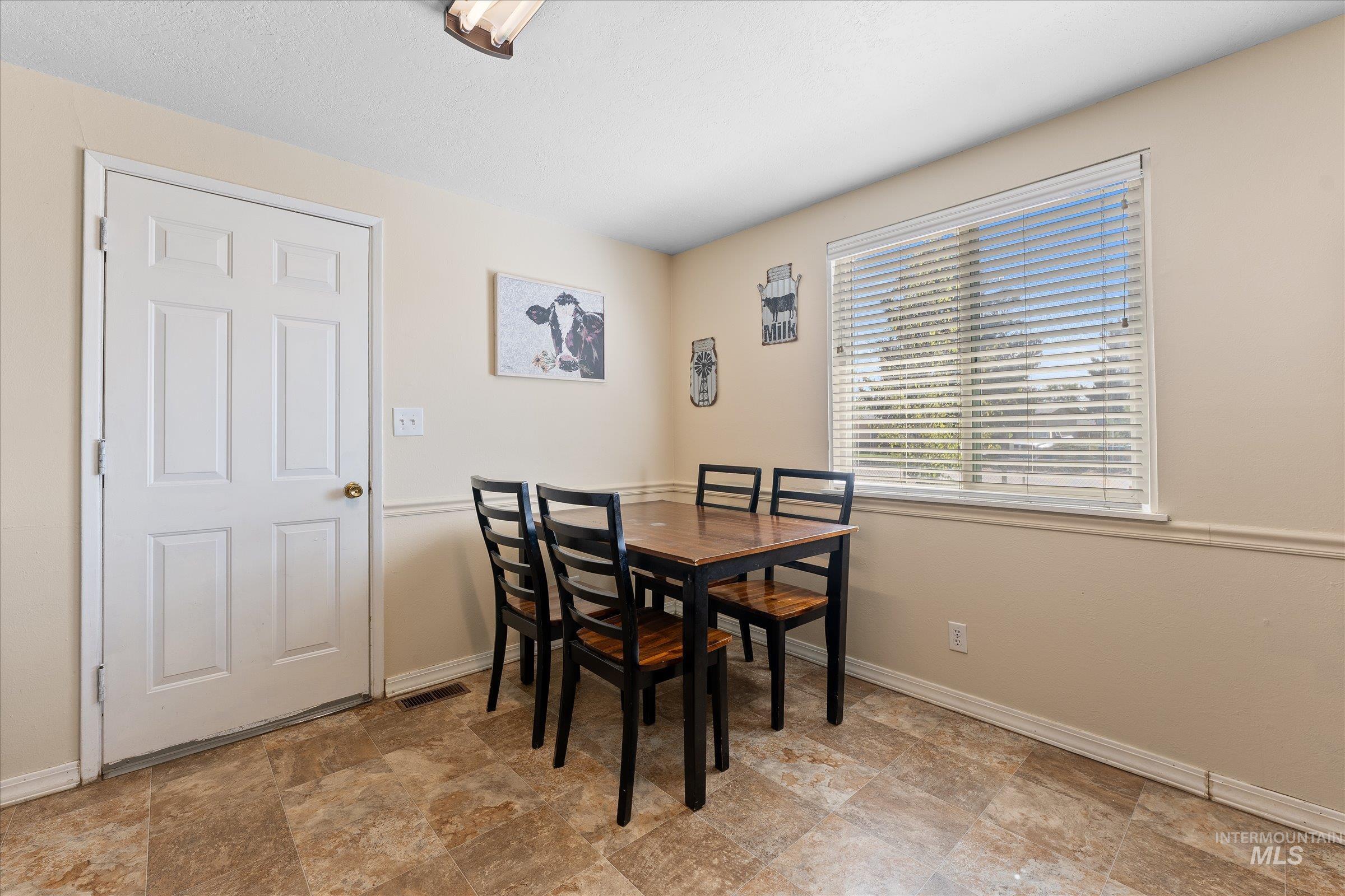 Dining area with baseboards and stone finish flooring