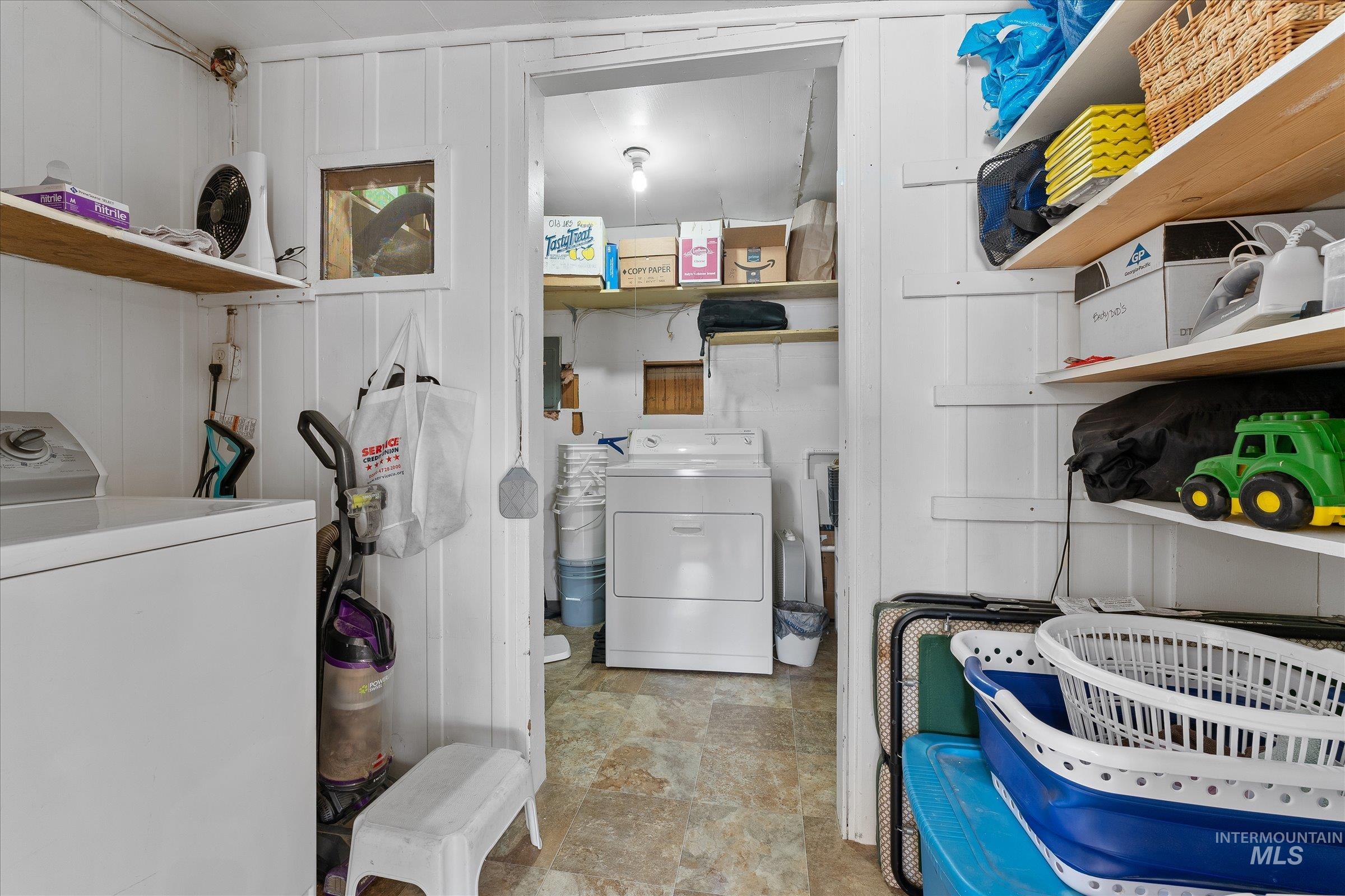Washroom featuring washer / clothes dryer and stone finish flooring