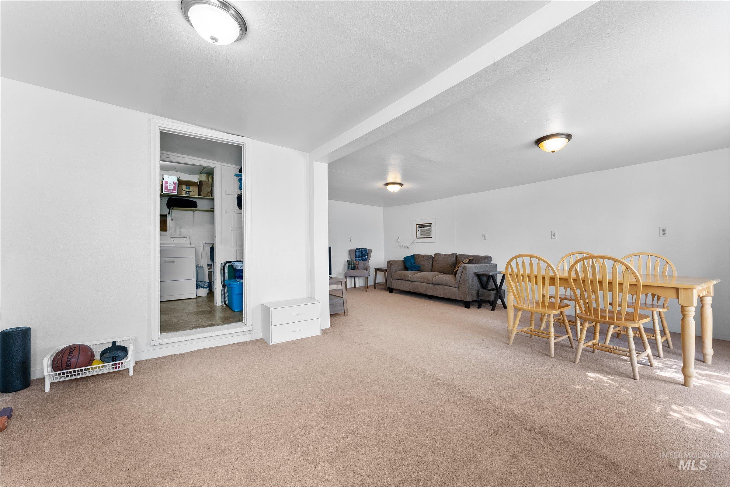 Living area with carpet floors and washer / dryer