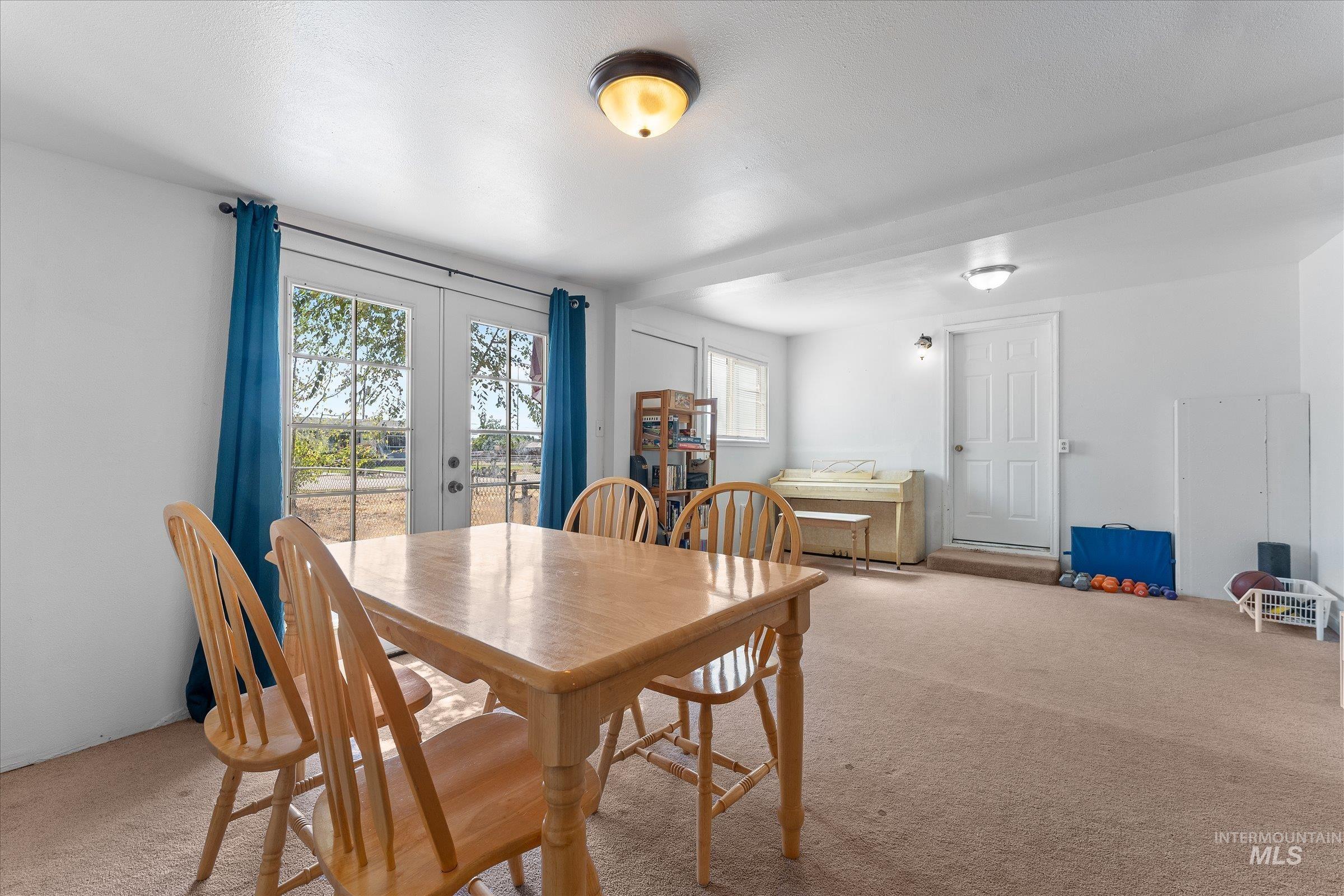 Carpeted dining area featuring french doors