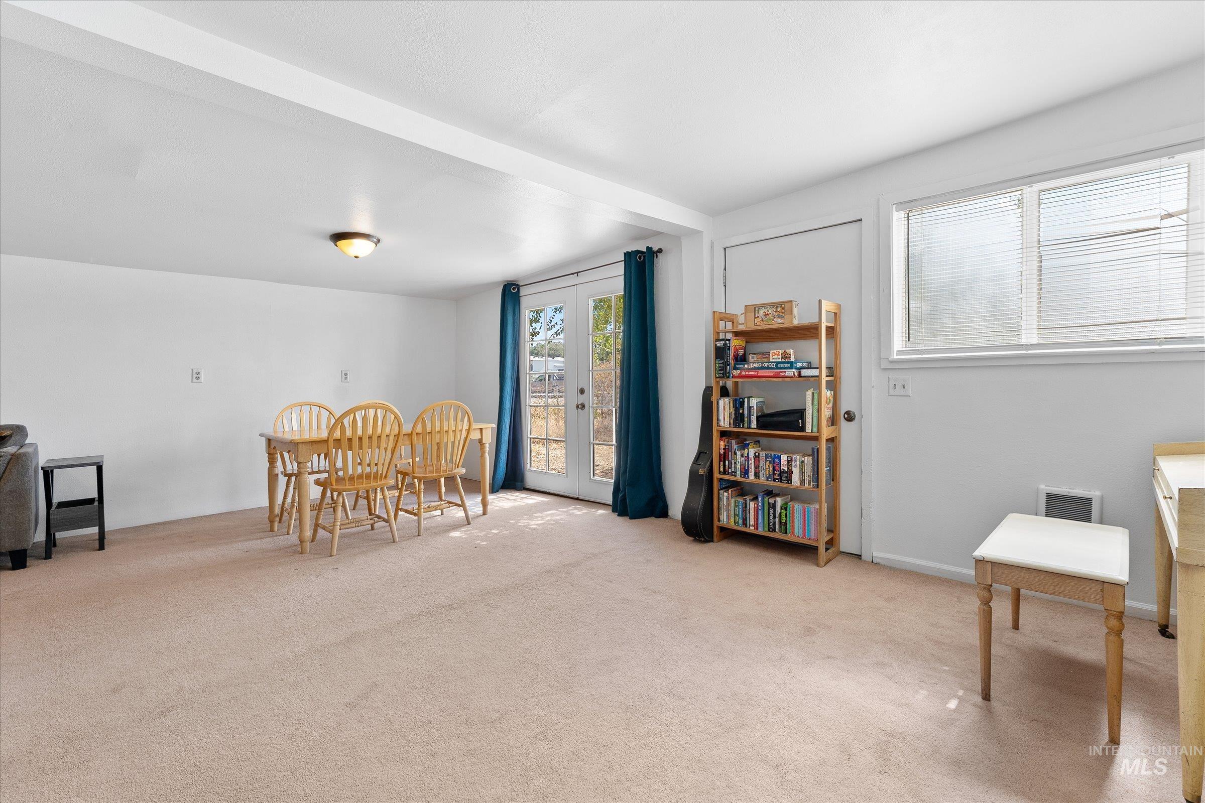 Living area featuring plenty of natural light, french doors, and light colored carpet
