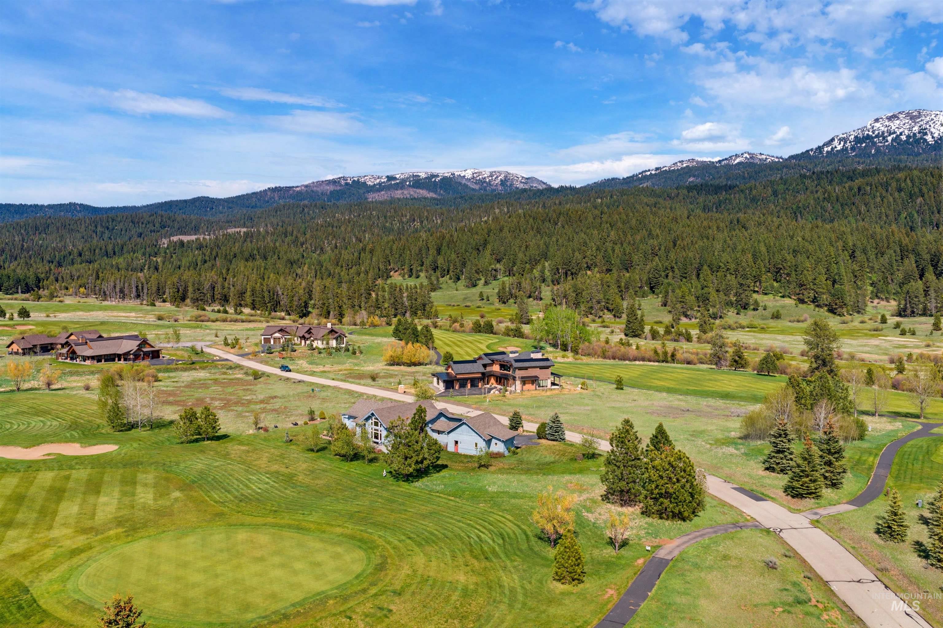 Aerial perspective showcasing a golf course green and surrounding properties
