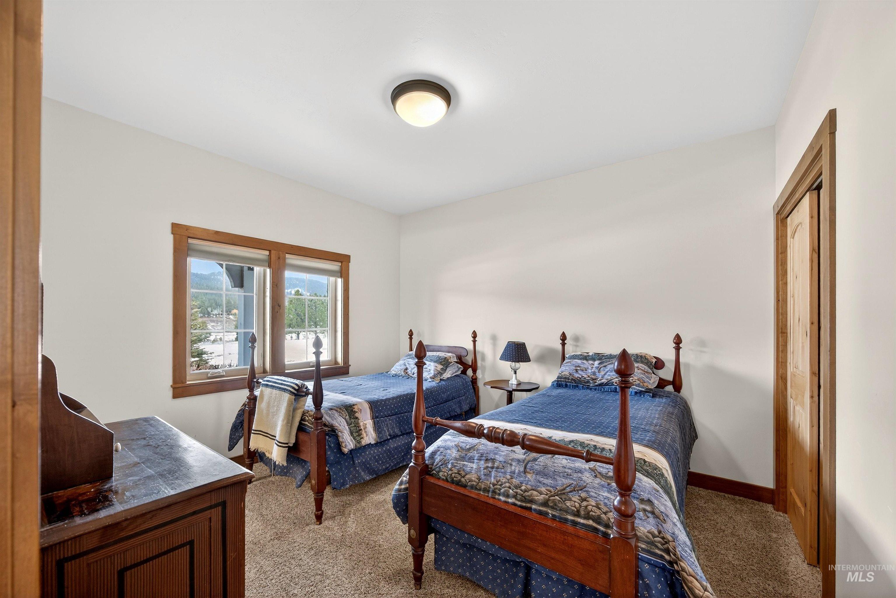 Bedroom with light colored carpet and baseboards