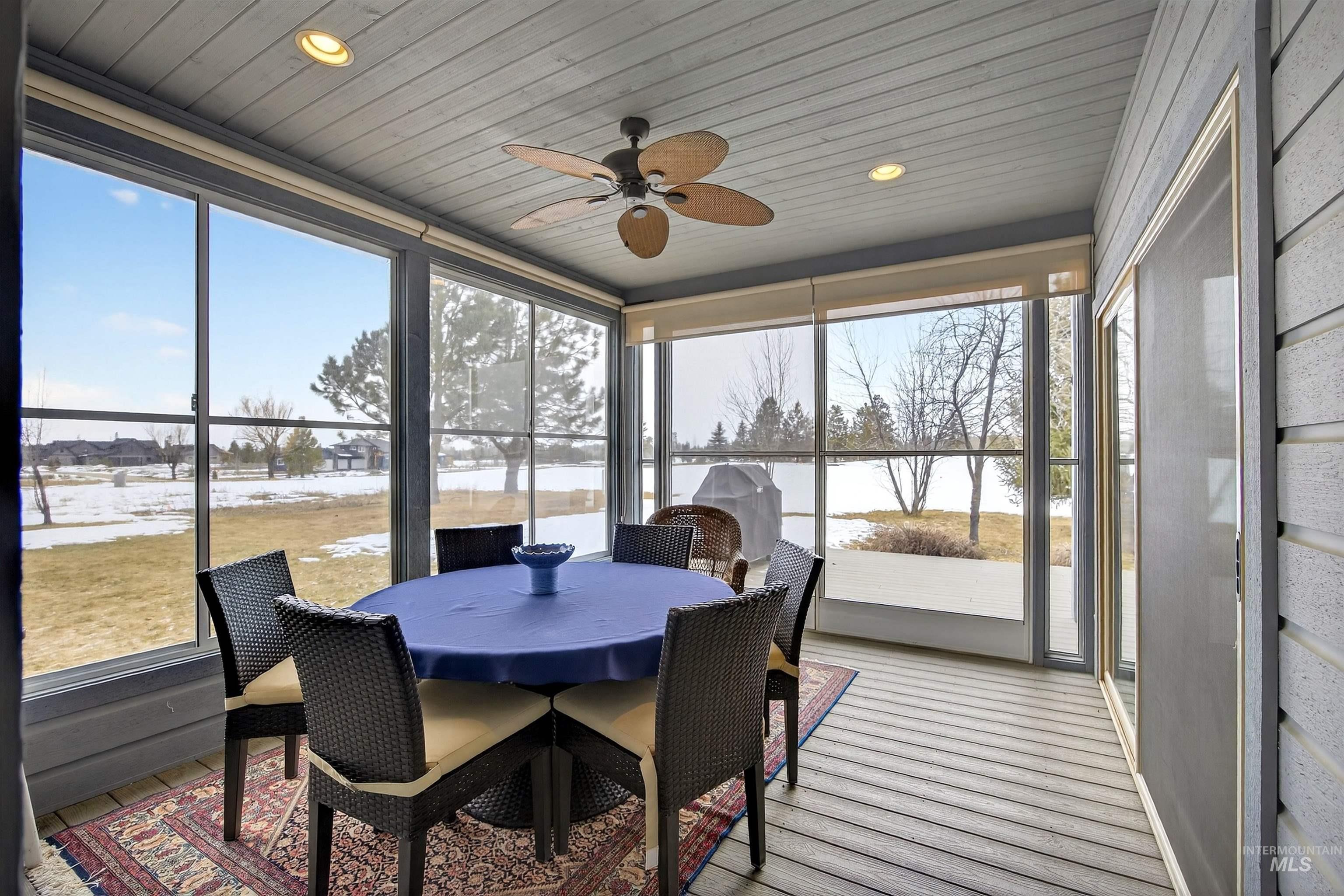 Screened porch featuring wood-finish flooring, a ceiling fan, recessed lighting, and expansive windows