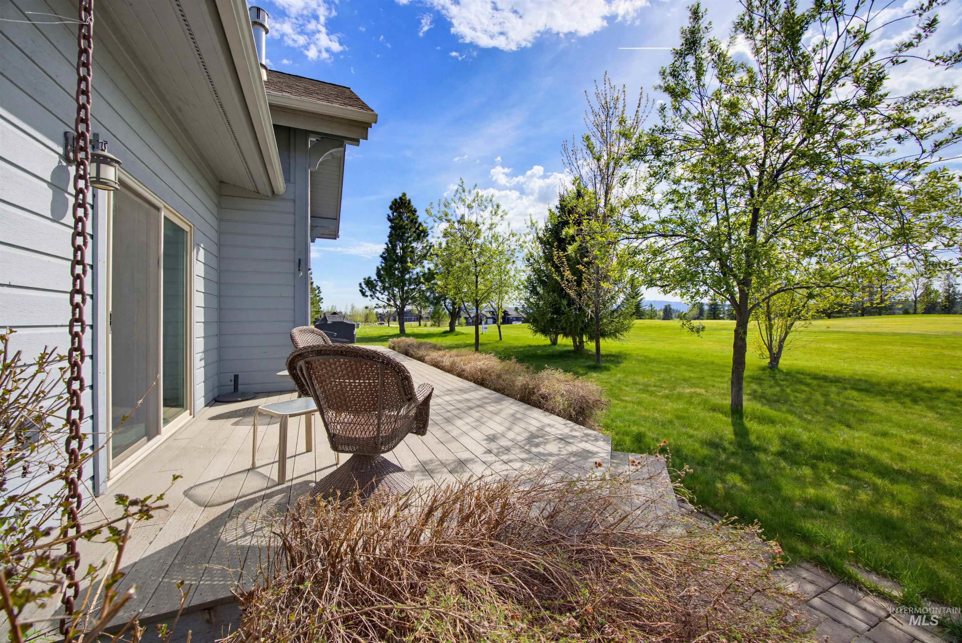 Spacious outdoor deck featuring wood-finish flooring, light blue siding, and a sliding glass door