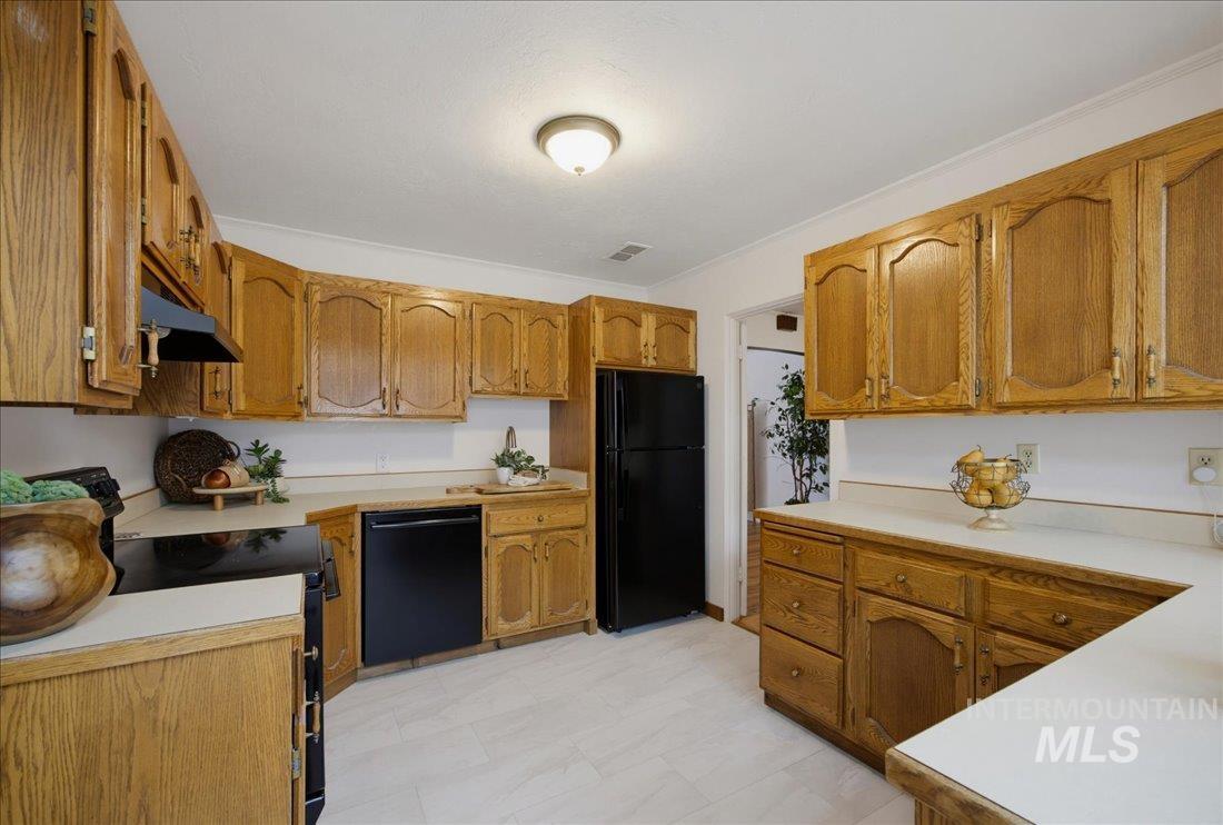 Kitchen featuring extensive wood cabinetry, light-colored countertops, and tile flooring