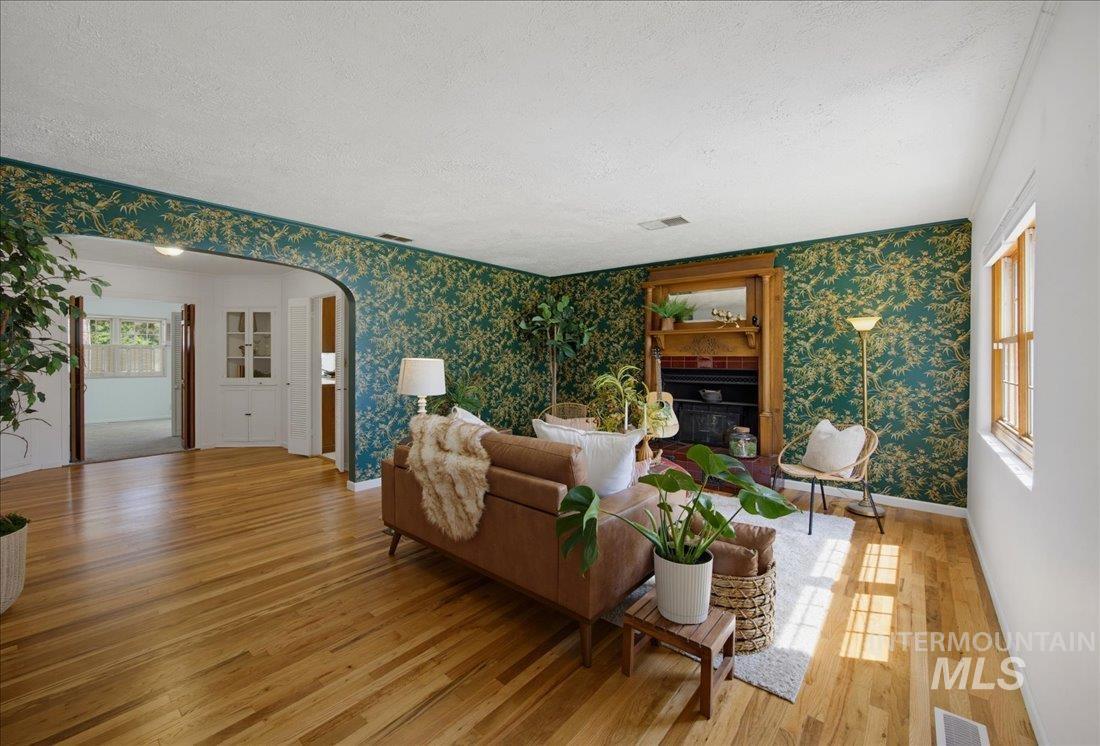 Living area featuring wood-finish flooring and a decorative fireplace with a wood mantel
