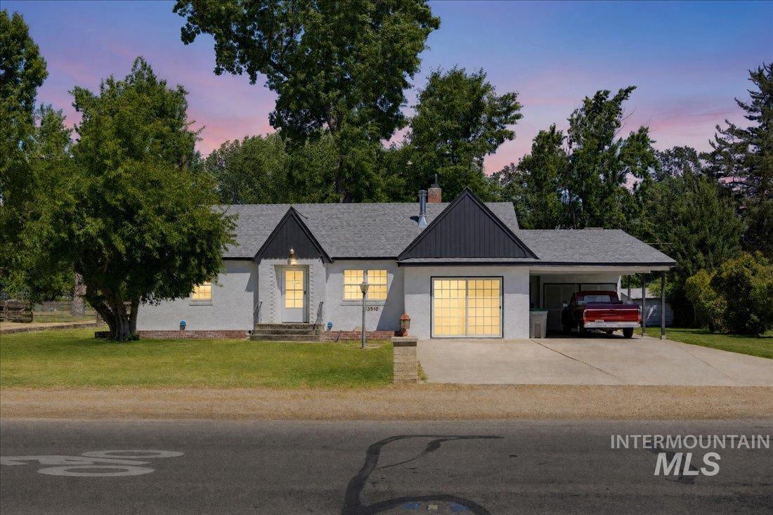 White stucco exterior with a dark shingled roof and contrasting black gable accents