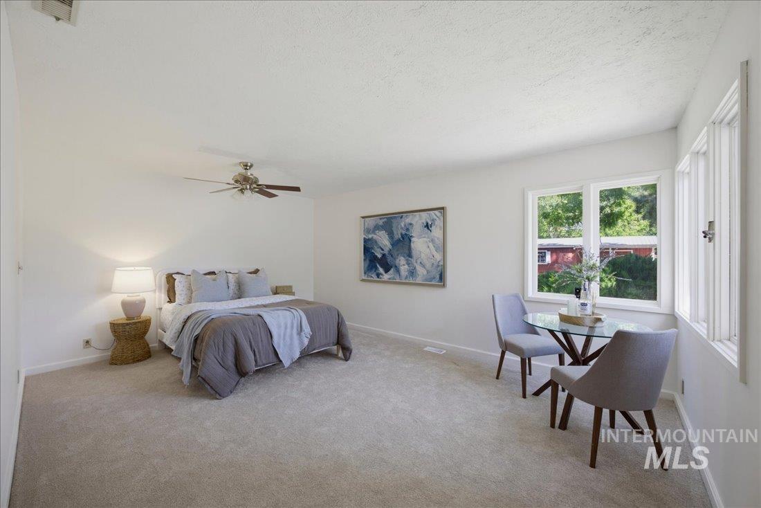 Spacious room featuring light carpeting and white walls