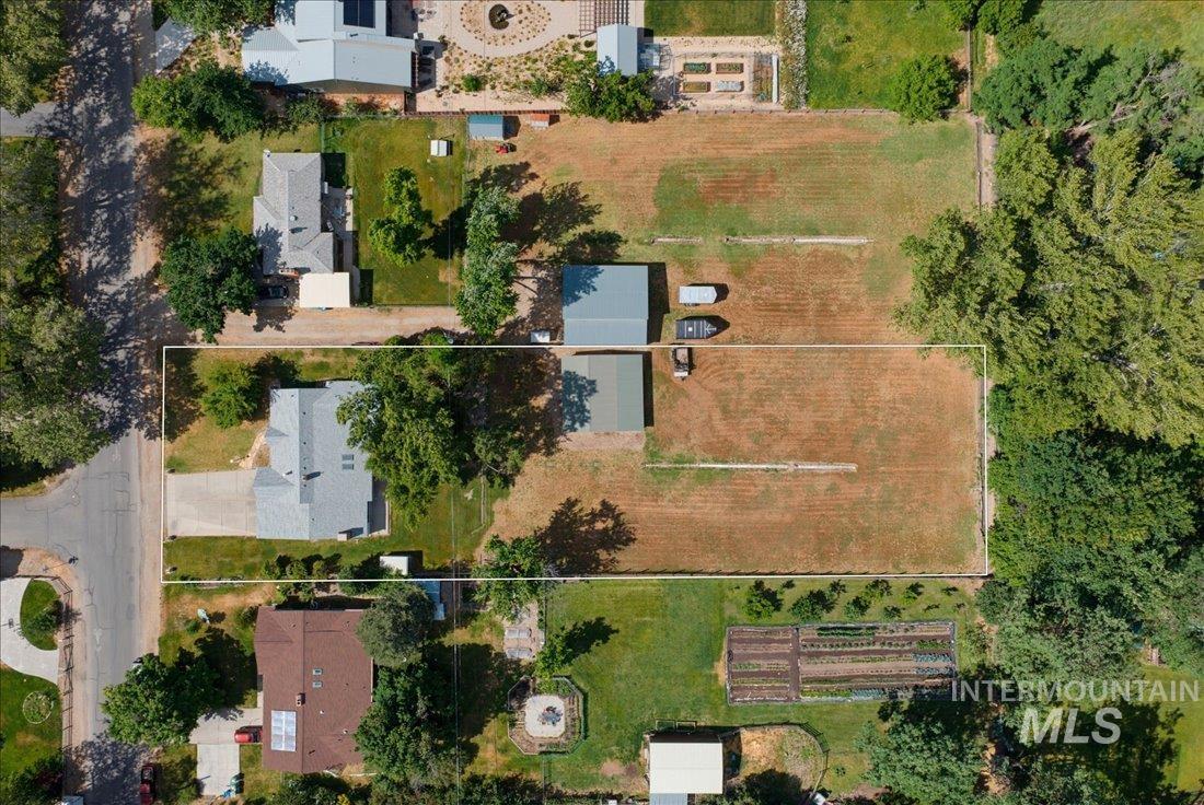 Expansive property featuring a main residence, an additional structure, mature trees, and a spacious undeveloped lot