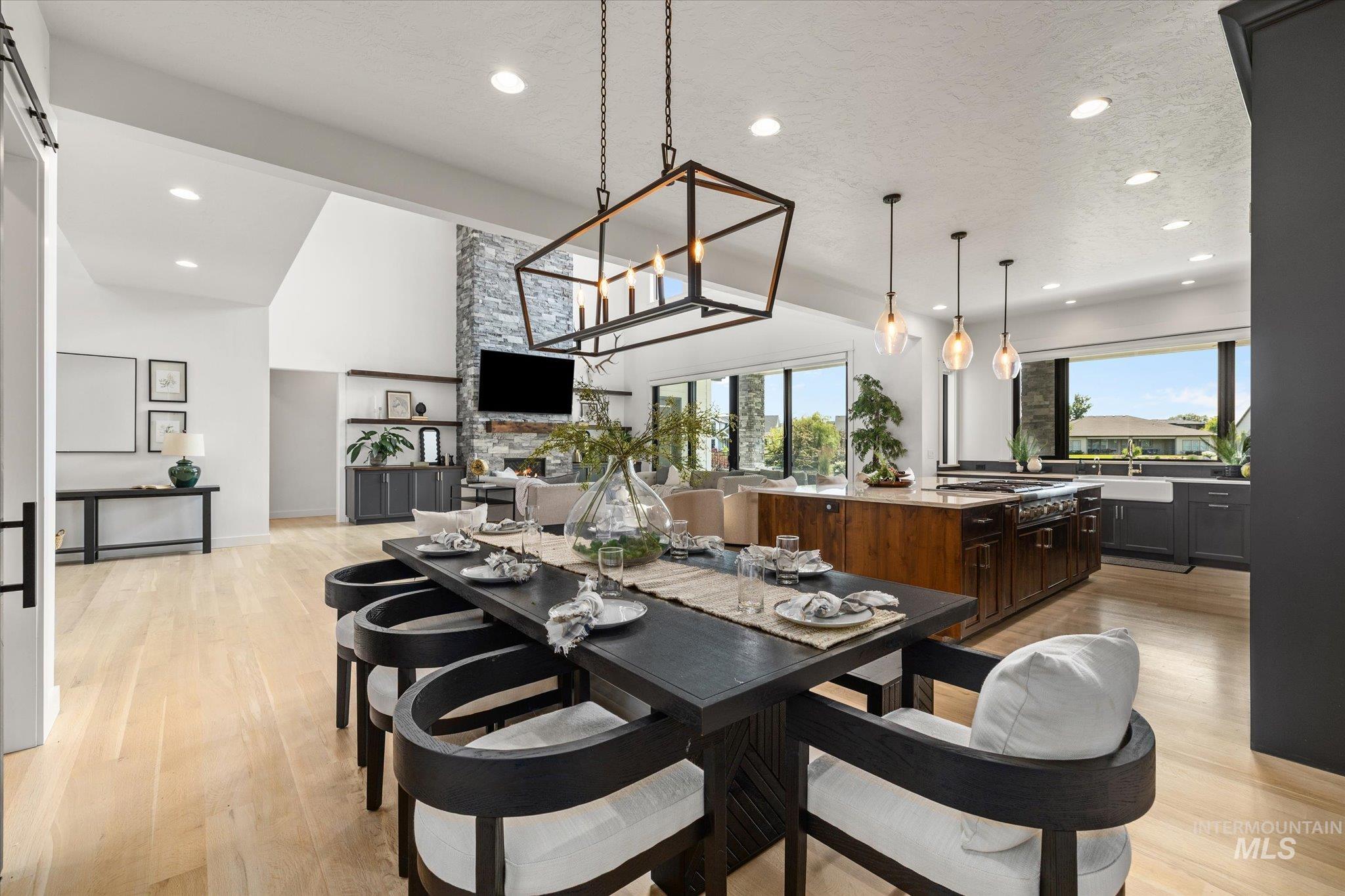 Dining area featuring light wood-type flooring, lofted ceiling, recessed lighting, and a chandelier