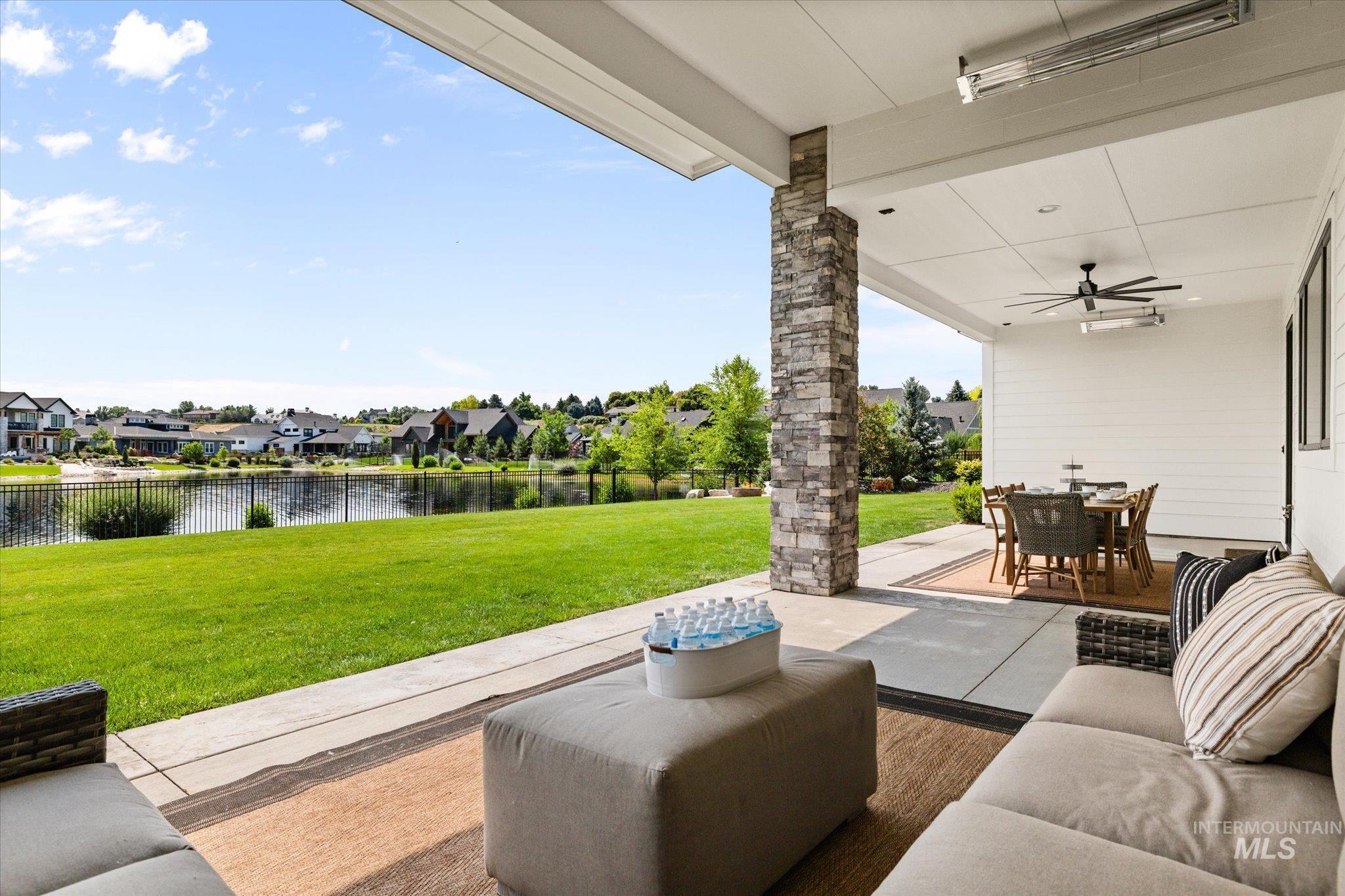 View of patio / terrace featuring a water view, outdoor dining area, a residential view, a ceiling fan, and an outdoor living space
