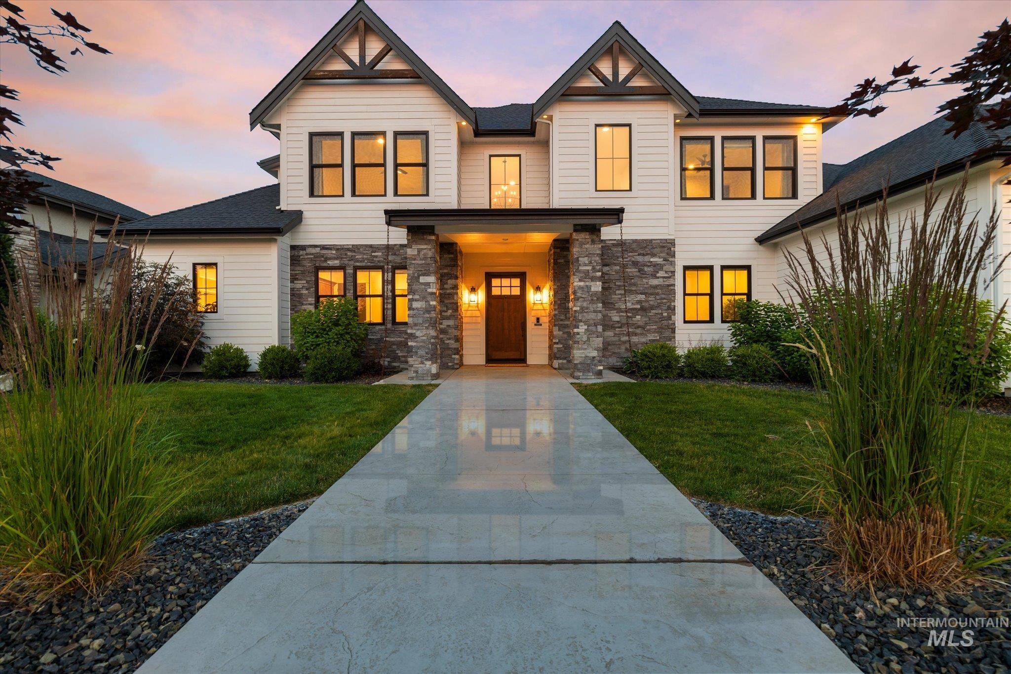 View of front of property with a yard and stone siding