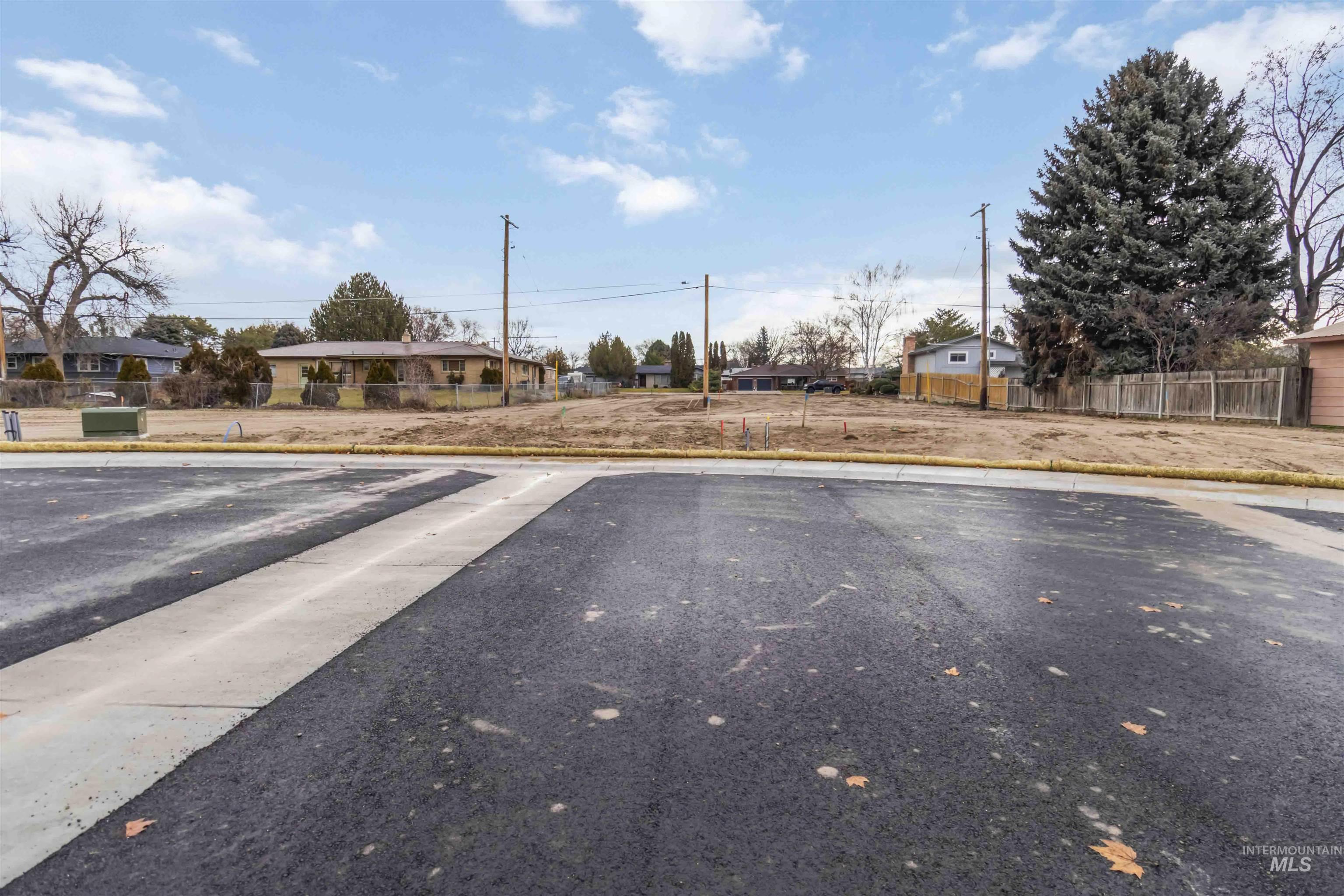 View of asphalt road with a residential view and curbs