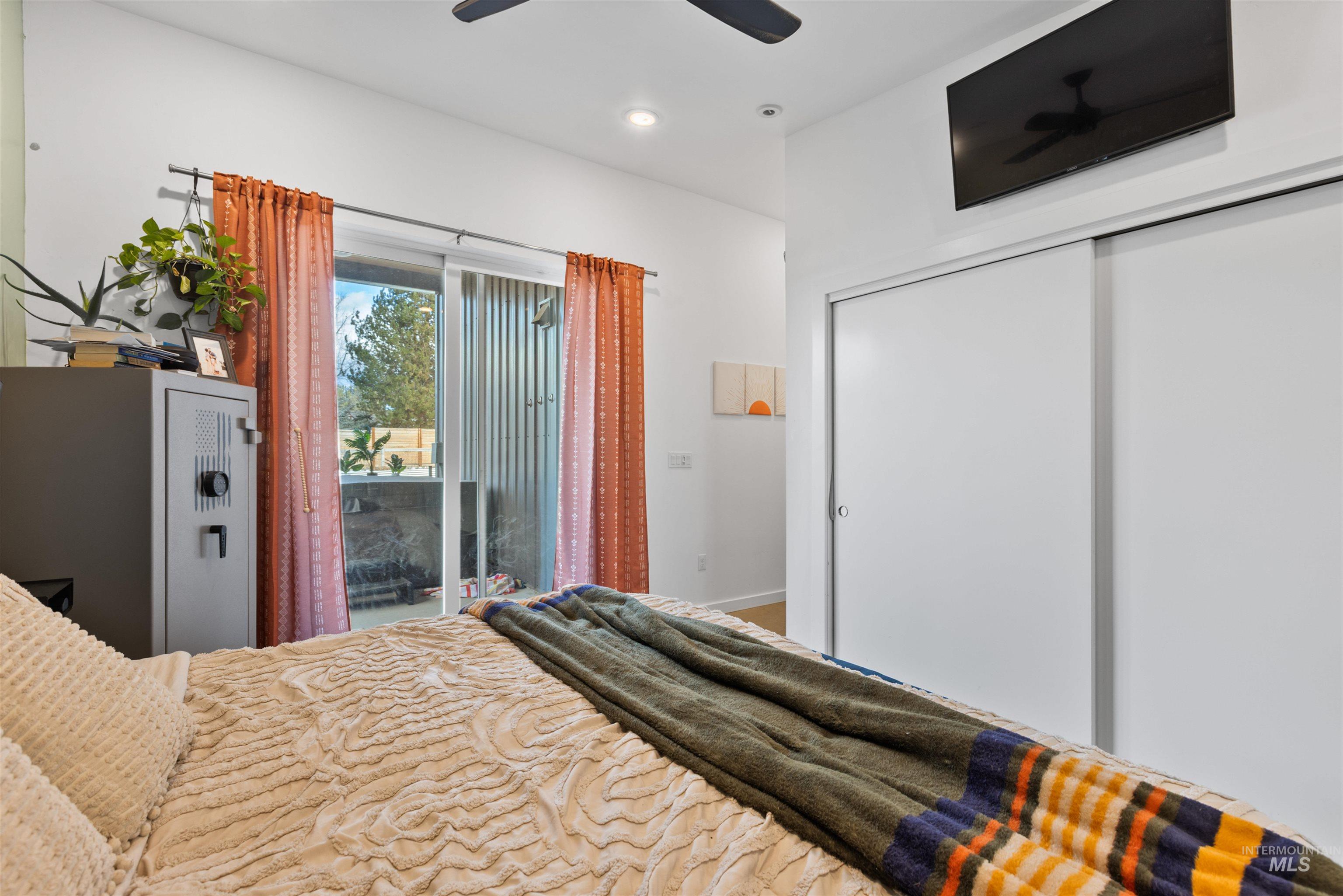 Bedroom with access to exterior, a closet, and a ceiling fan