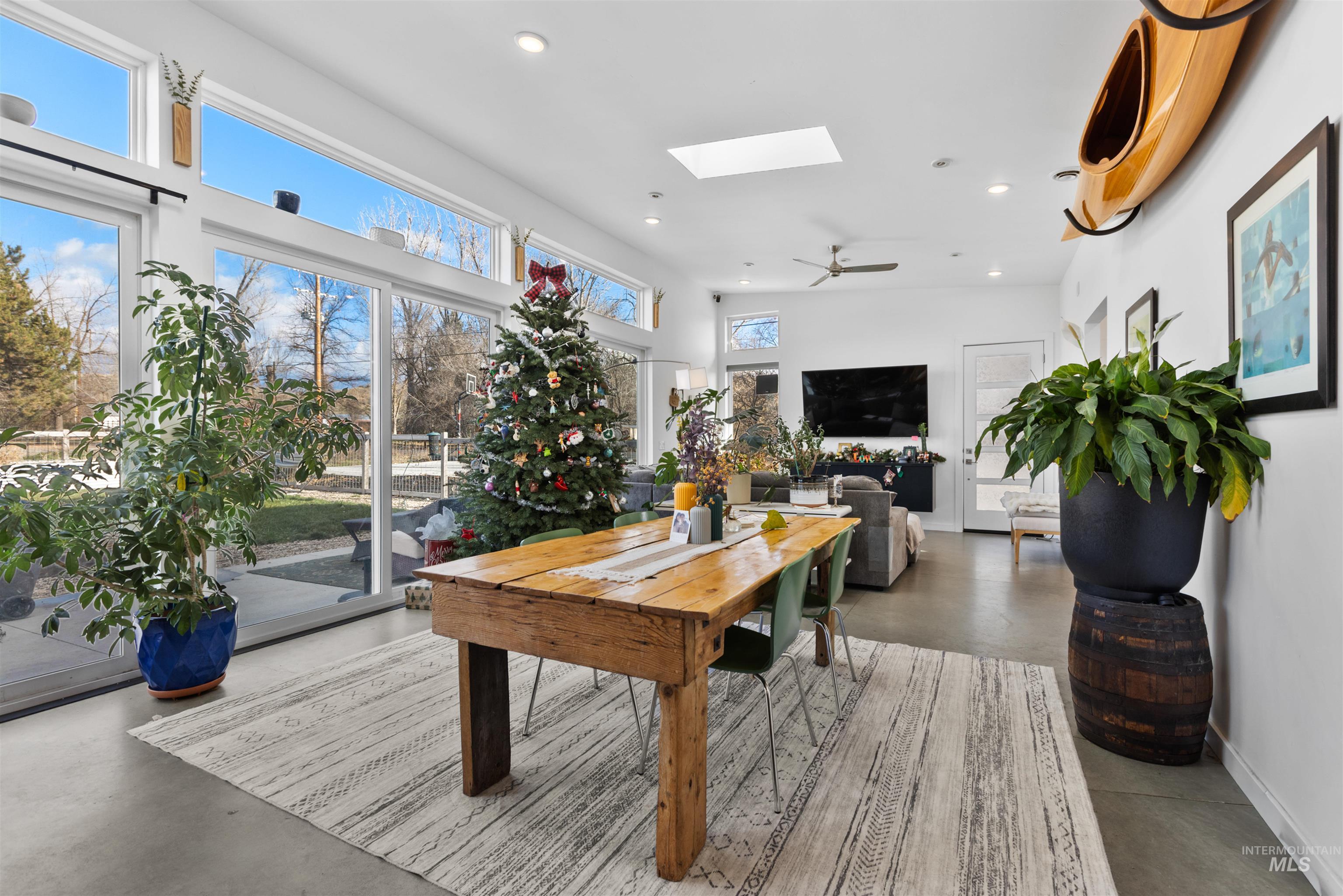 Dining room with a skylight, finished concrete flooring, ceiling fan, and recessed lighting