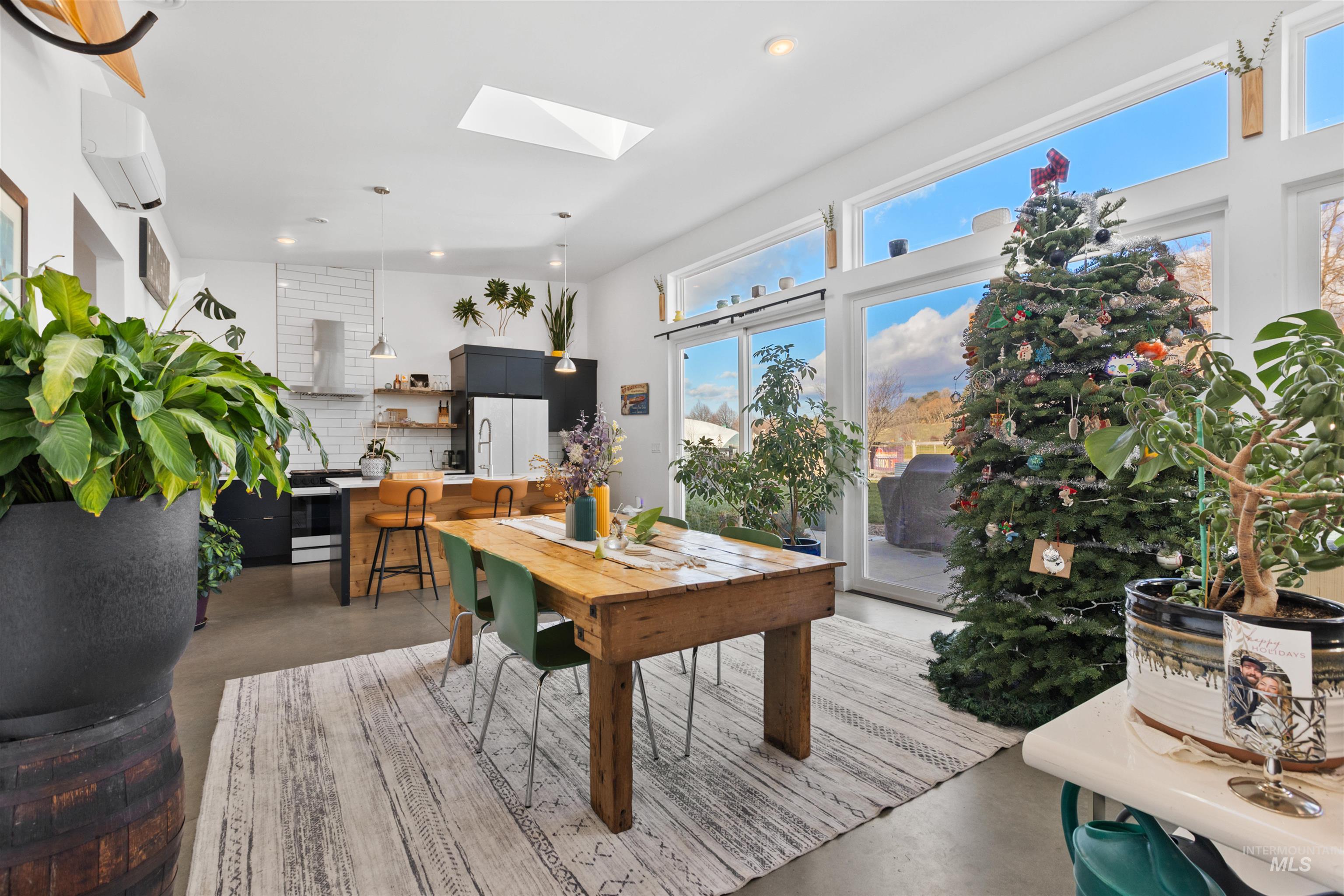 Dining area featuring a skylight, finished concrete flooring, a wall unit AC, and recessed lighting