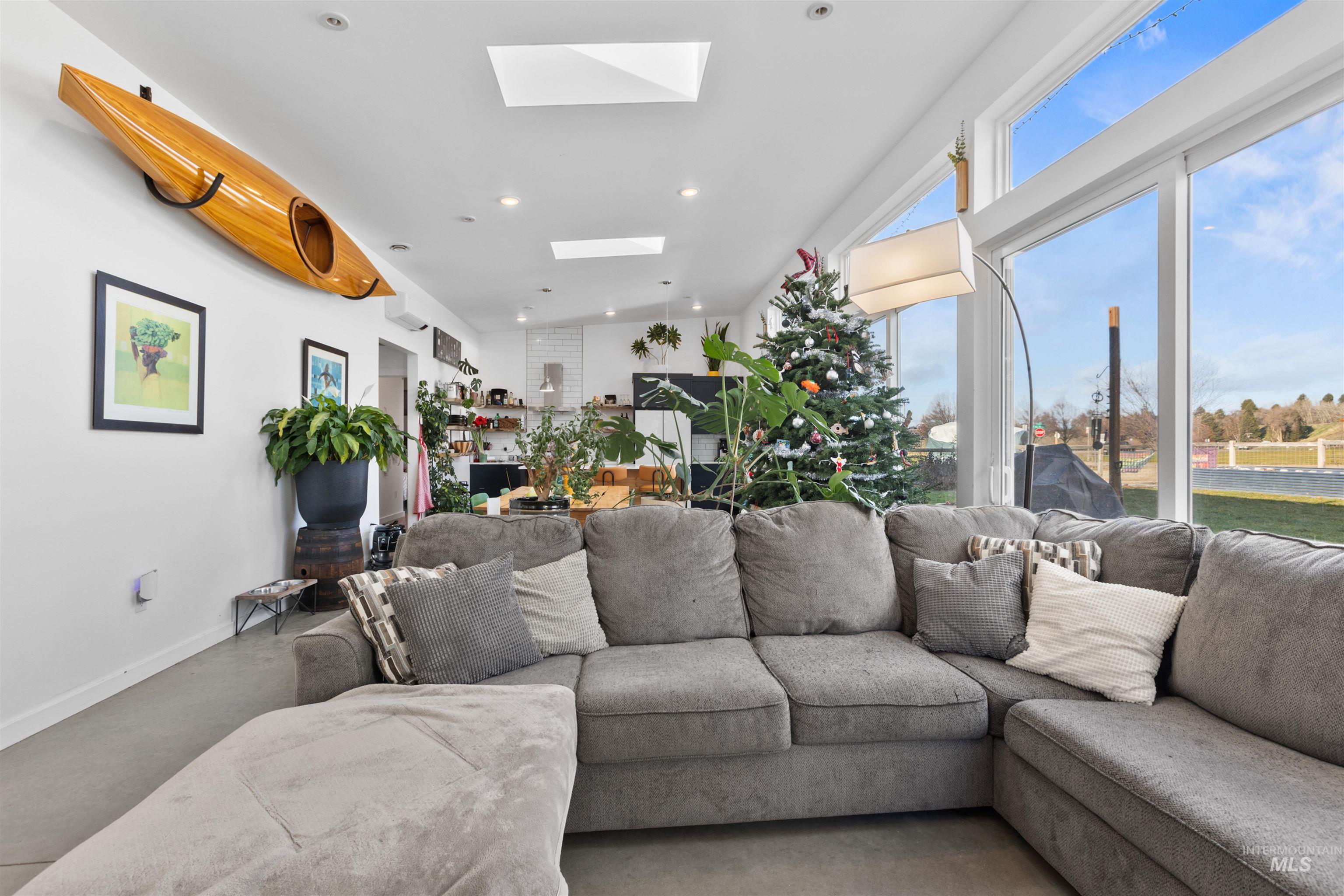 Living area with finished concrete flooring, a skylight, and recessed lighting