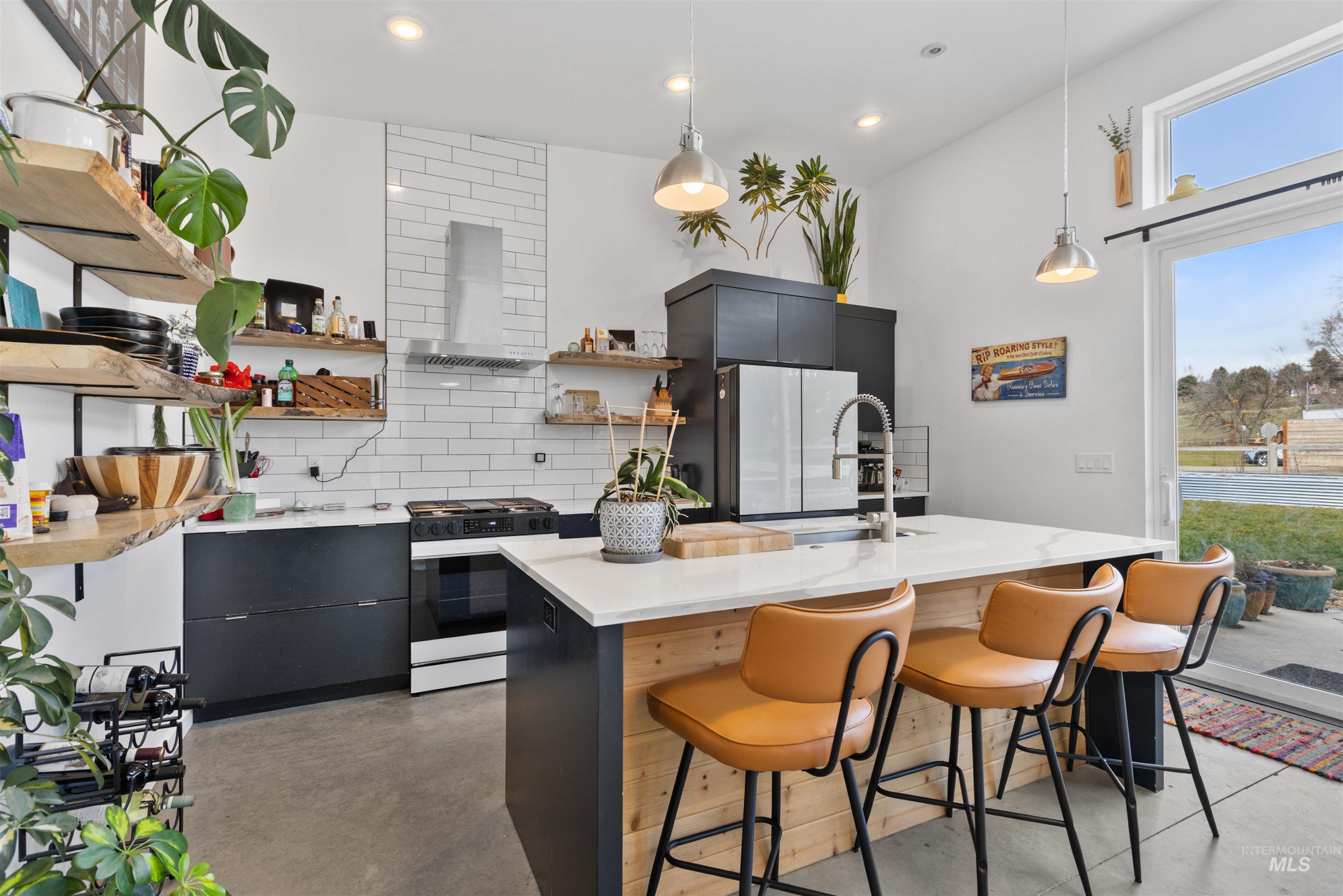 Kitchen featuring dark cabinetry, modern cabinets, open shelves, backsplash, and gas range