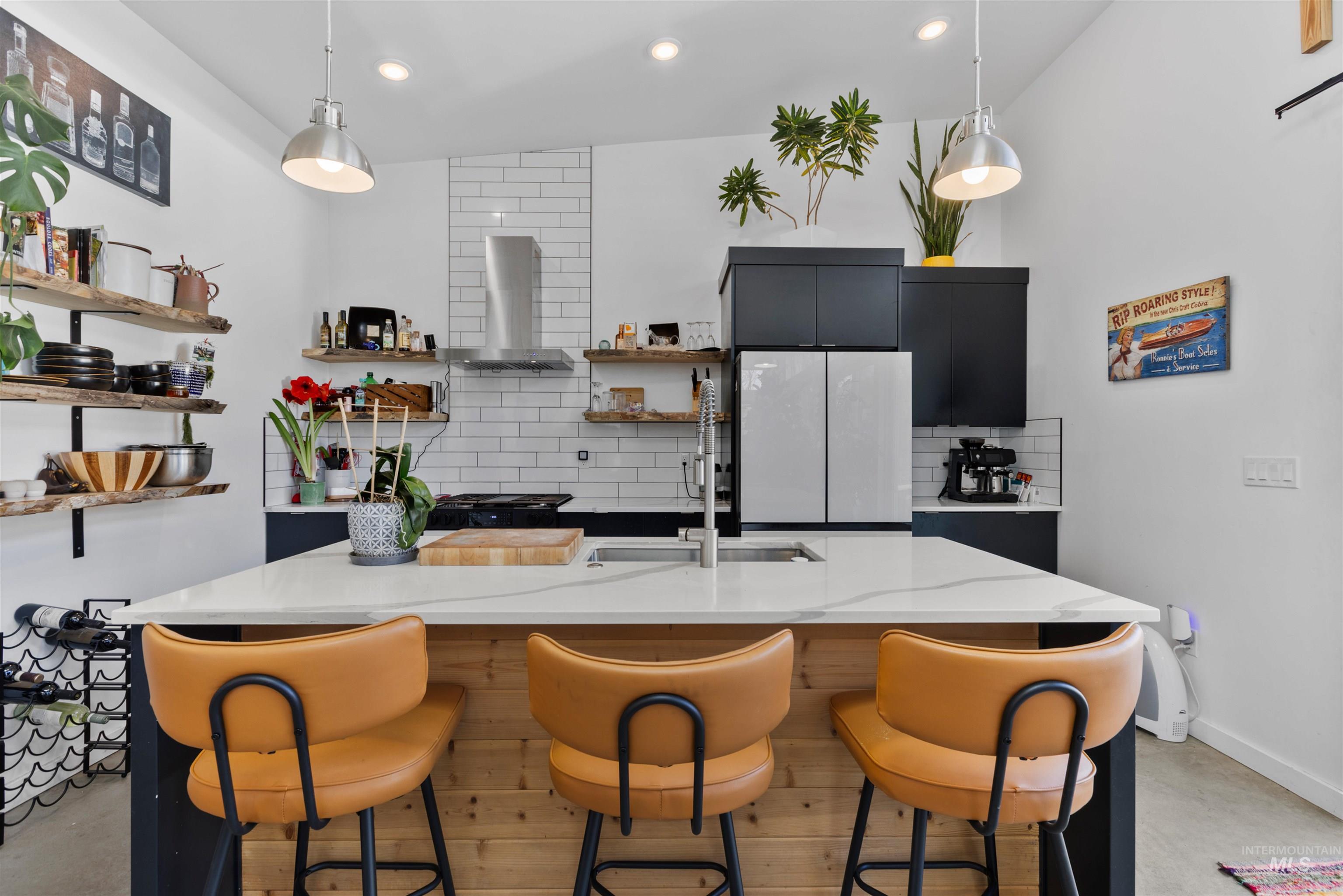 Kitchen featuring dark cabinets, finished concrete floors, backsplash, and recessed lighting